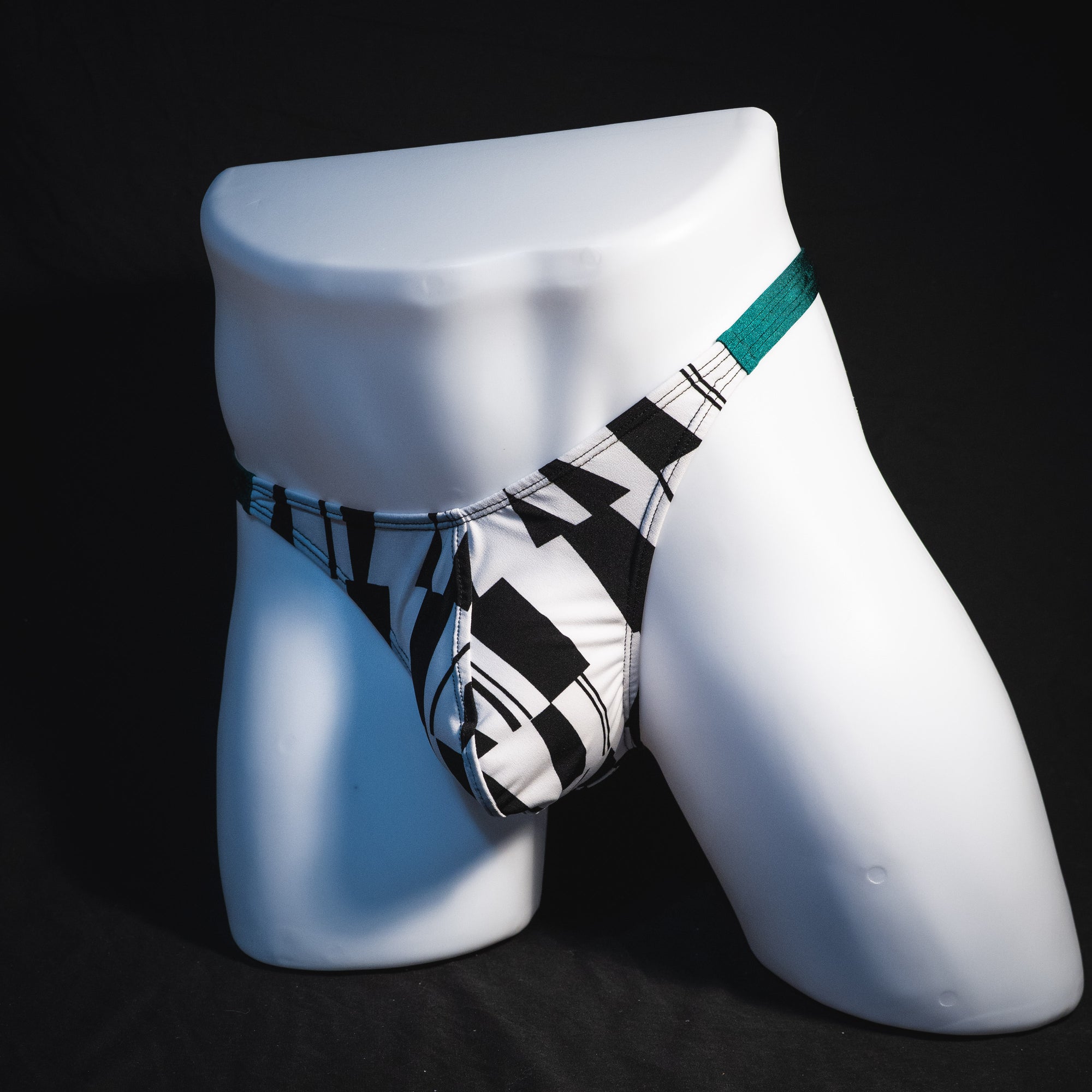 Men's black and white geometric thong underwear with green side straps, classic cut, Full front angled view