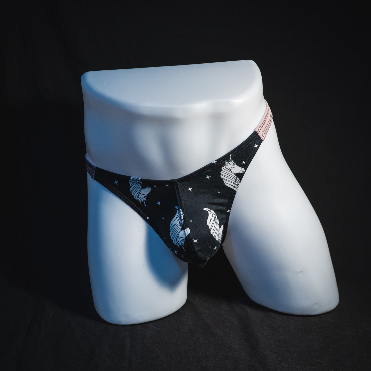 Men's black and white unicorn thong underwear, classic cut, full front view.