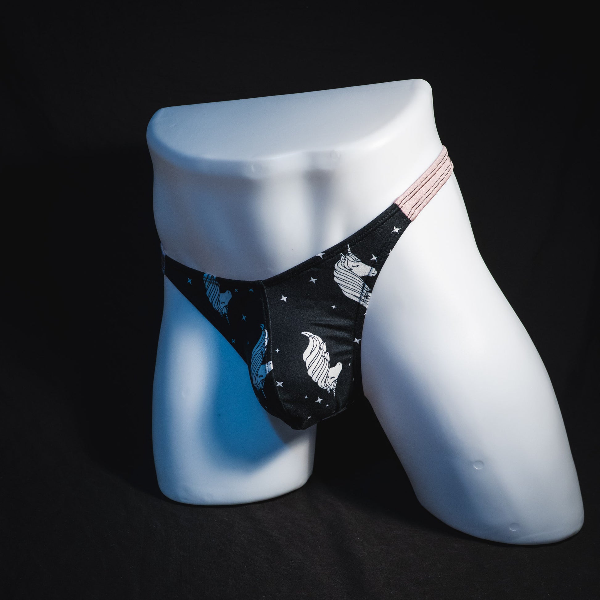 Men's black and white unicorn thong underwear, classic cut, full angled front view.