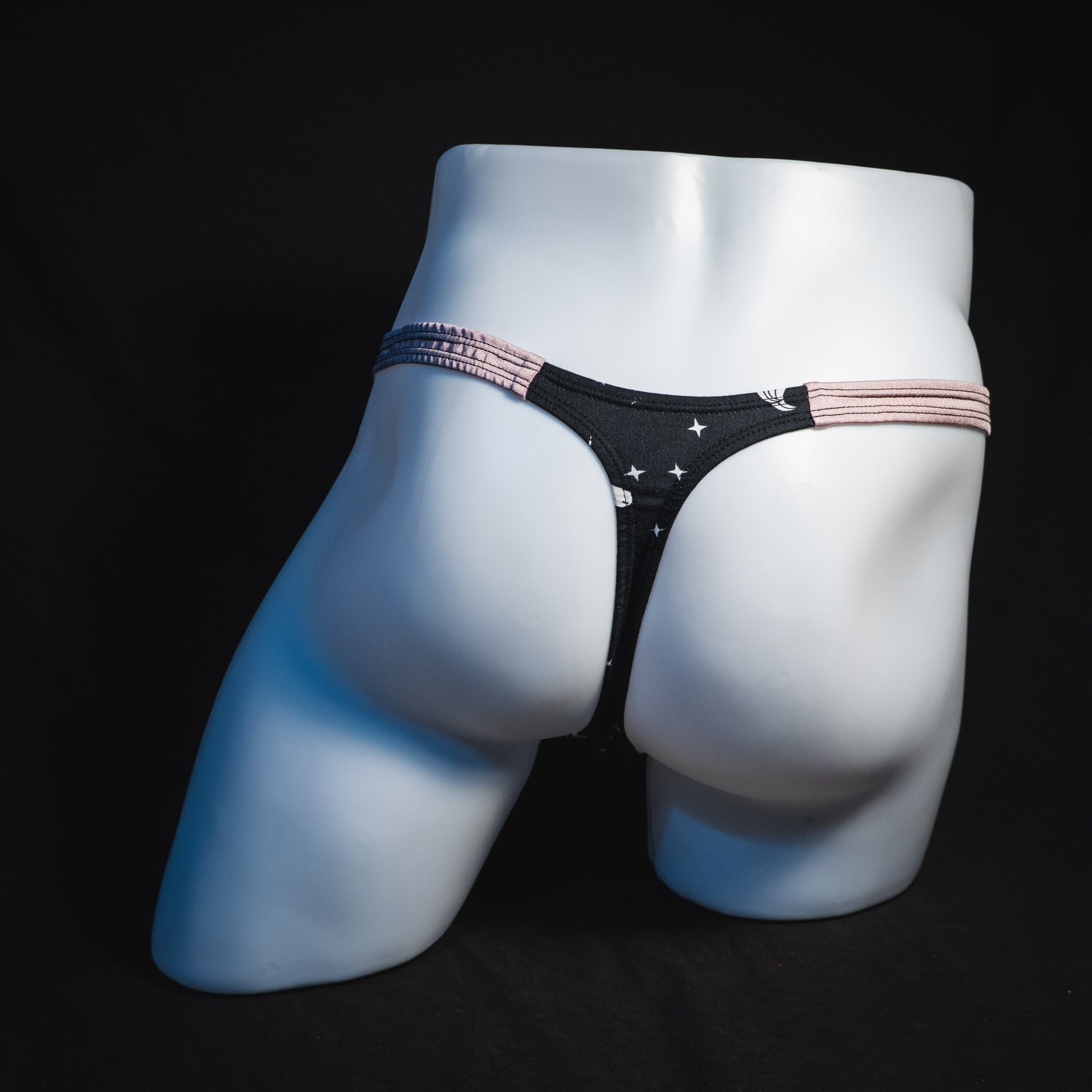 Men's black and white unicorn thong underwear, classic cut, full rear view.