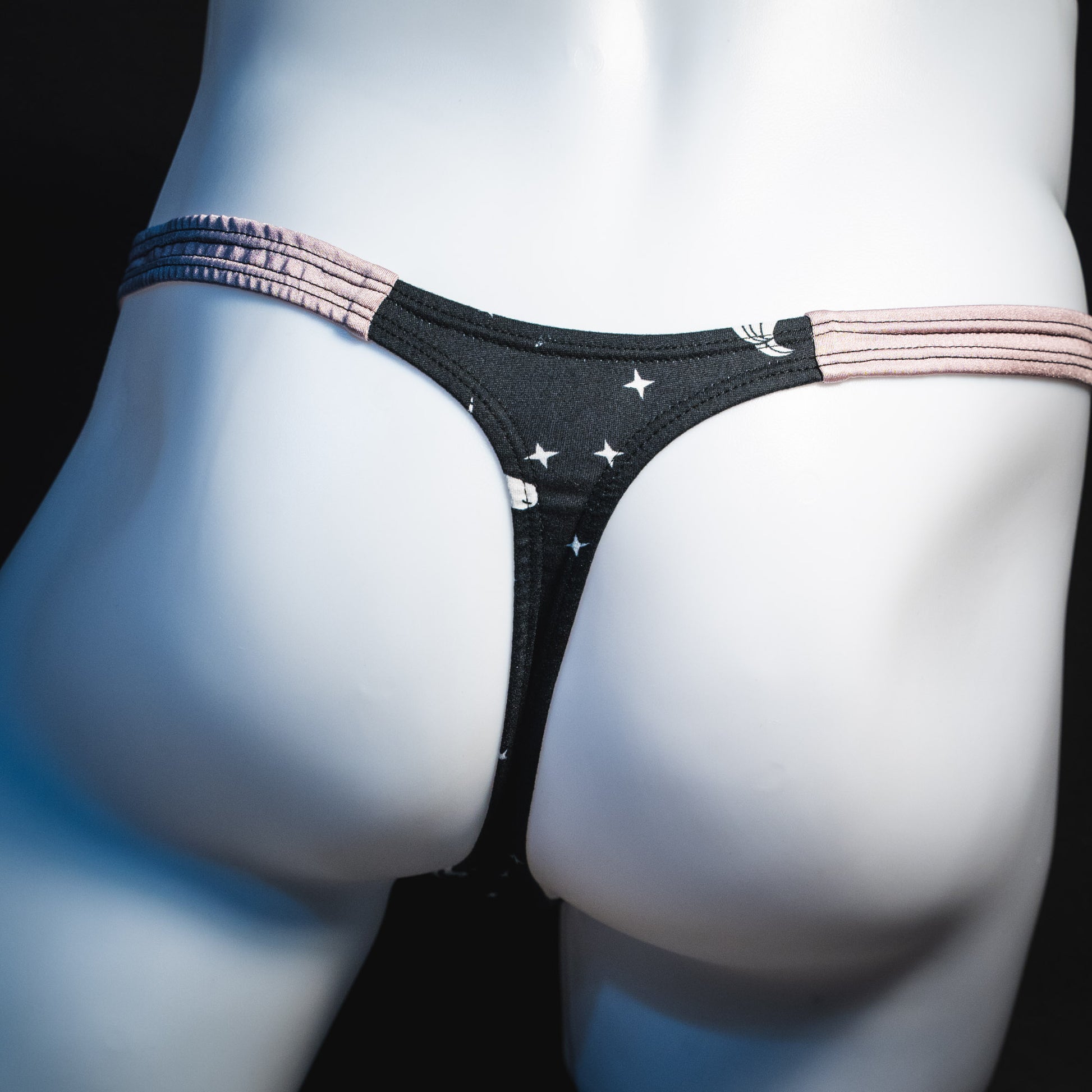 Men's black and white unicorn thong underwear, classic cut, rear view.