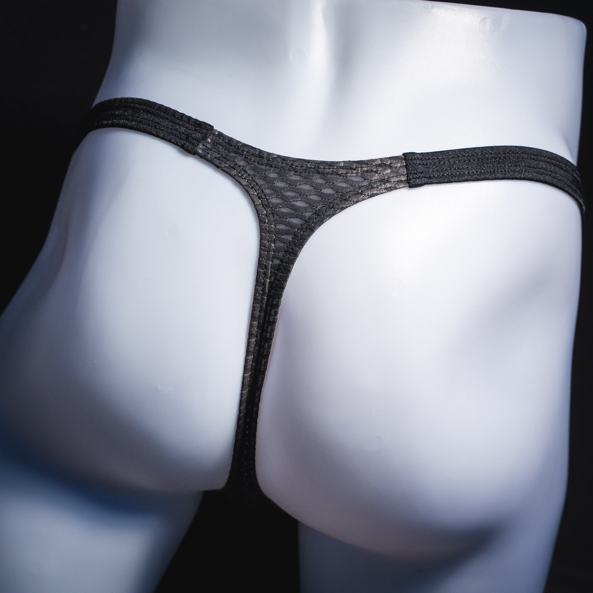 Men's black athletic mesh thong underwear, classic cut, rear view.