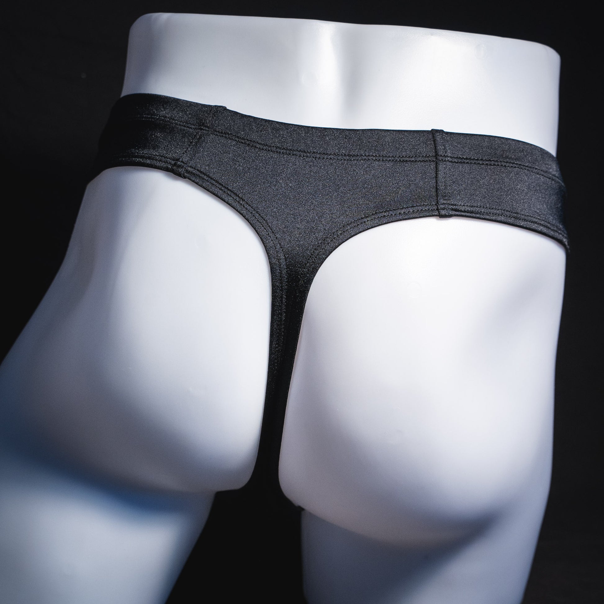 Men's black brief cut thong underwear, rear view.