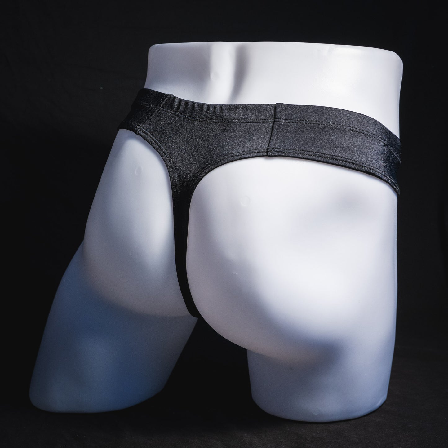 Men's black brief cut thong underwear, full angled rear view.