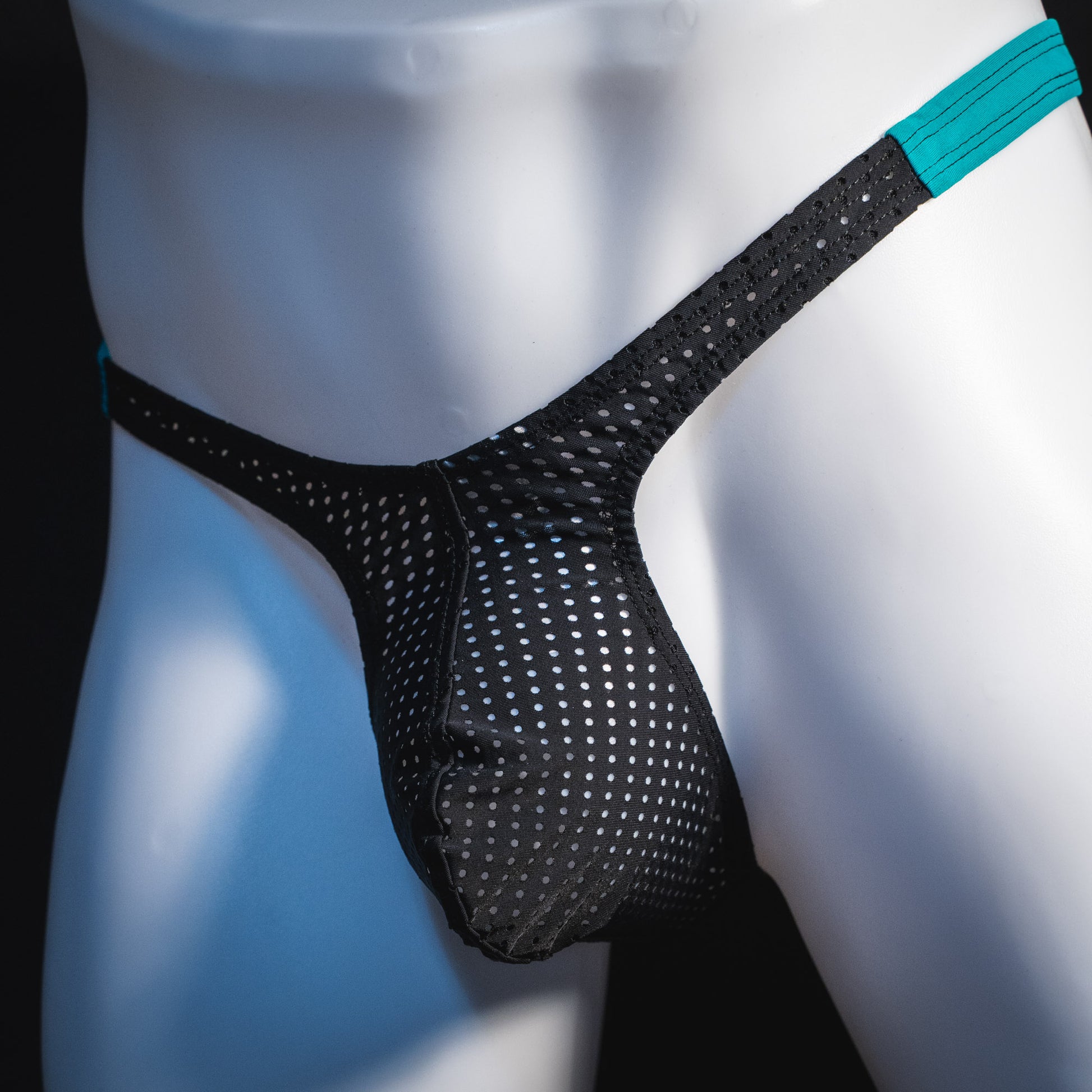 Black mesh with teal waistband, men's thong underwear, tower cut, angled front view.