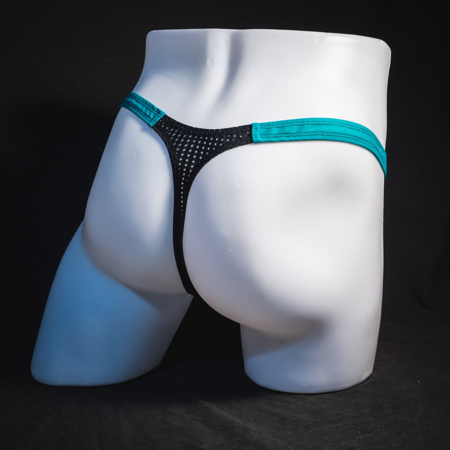 Black mesh with teal waistband, men's thong underwear, tower cut, full angled rear view.