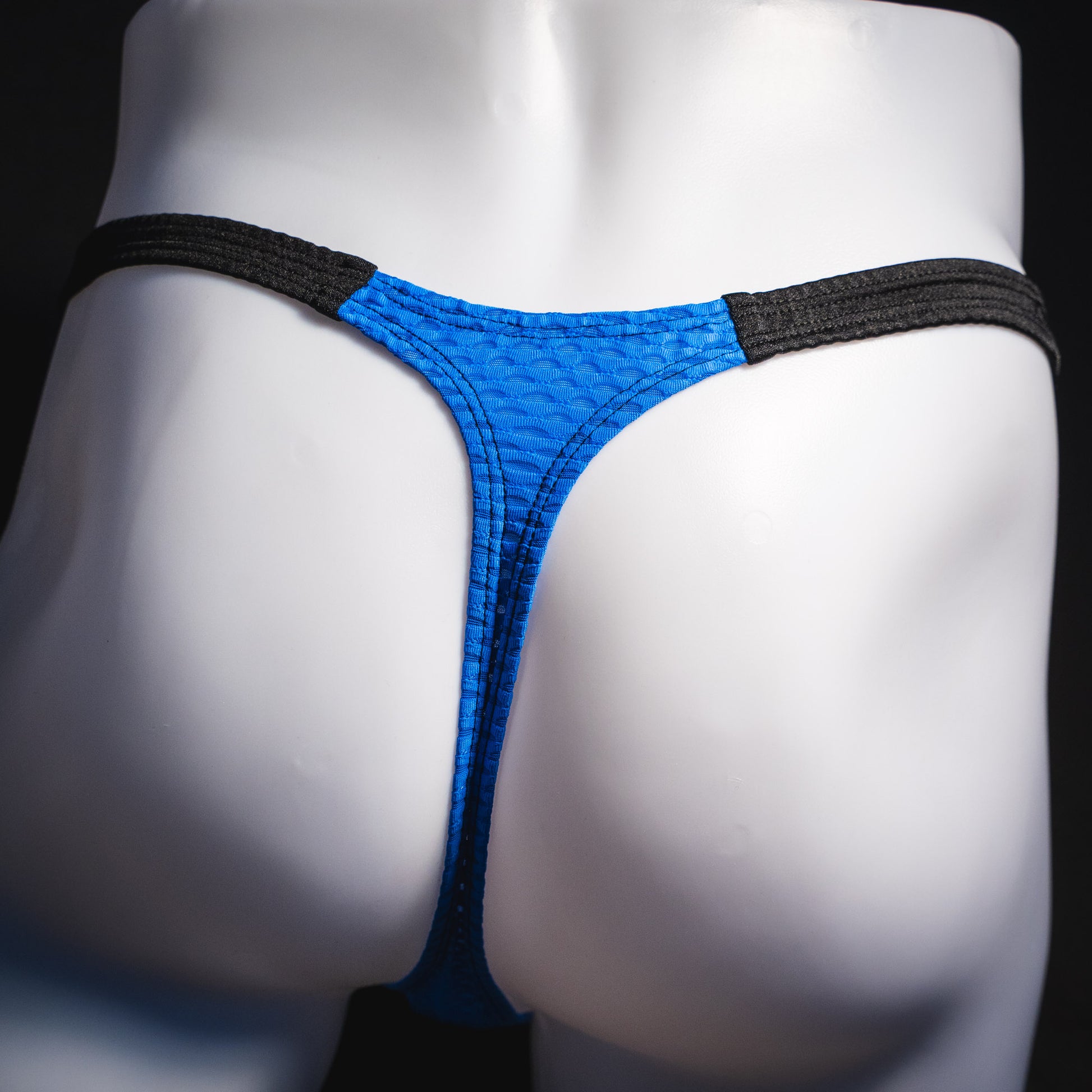 Men's blue and black athletic mesh thong underwear, classic cut, rear view.