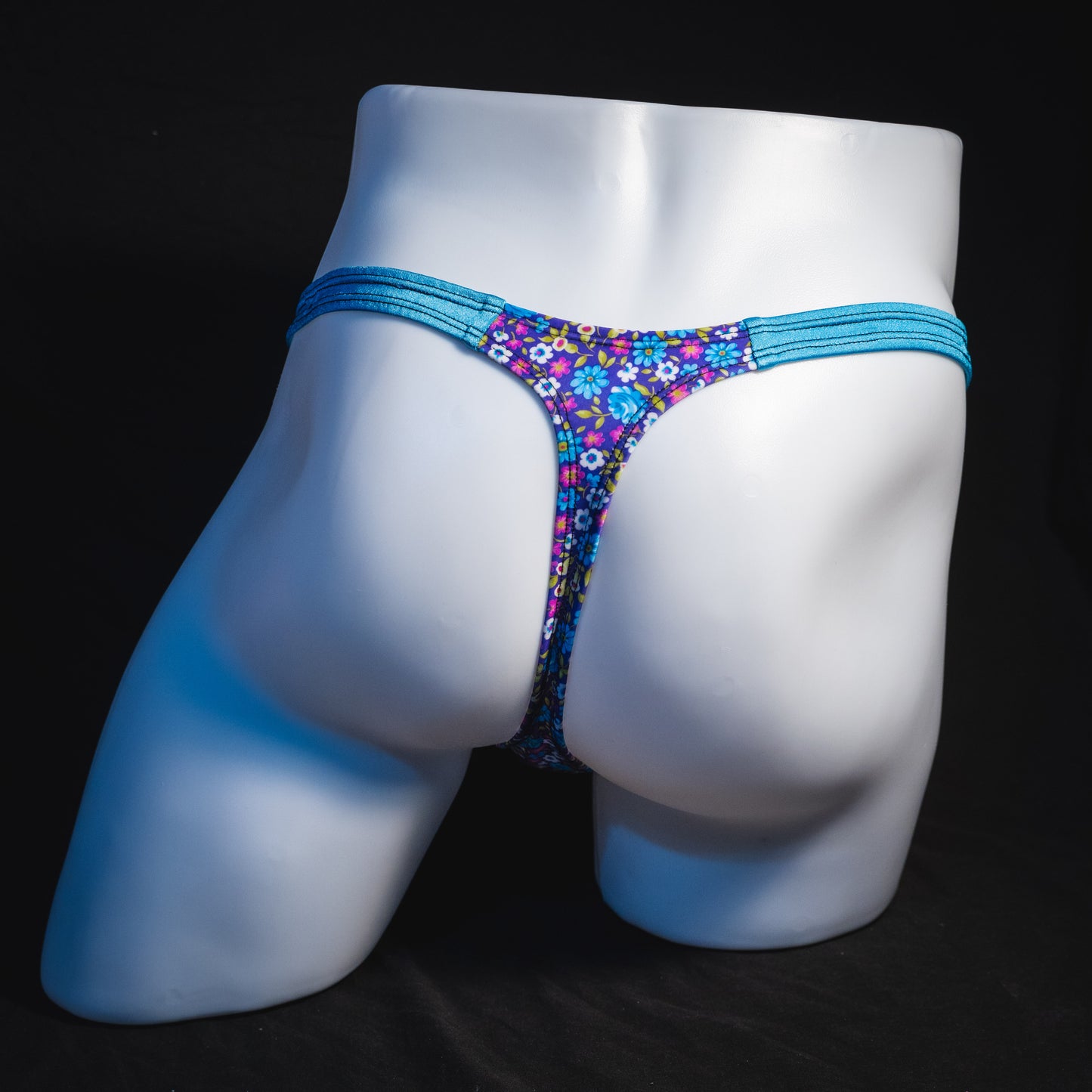 Men's blue and purple flower patch thong underwear, classic cut, full rear view.