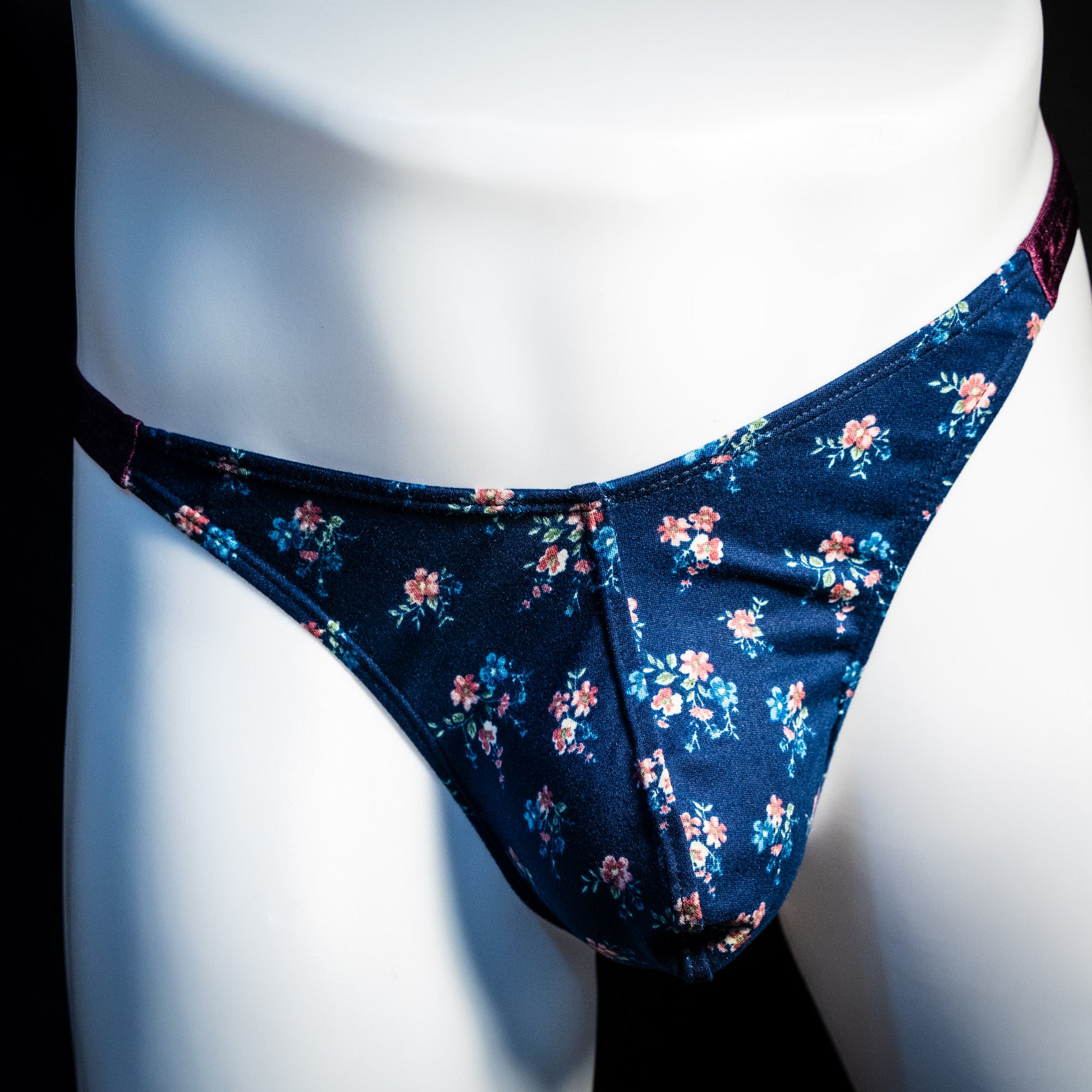 Men's blue floral thong underwear, classic cut, front view.
