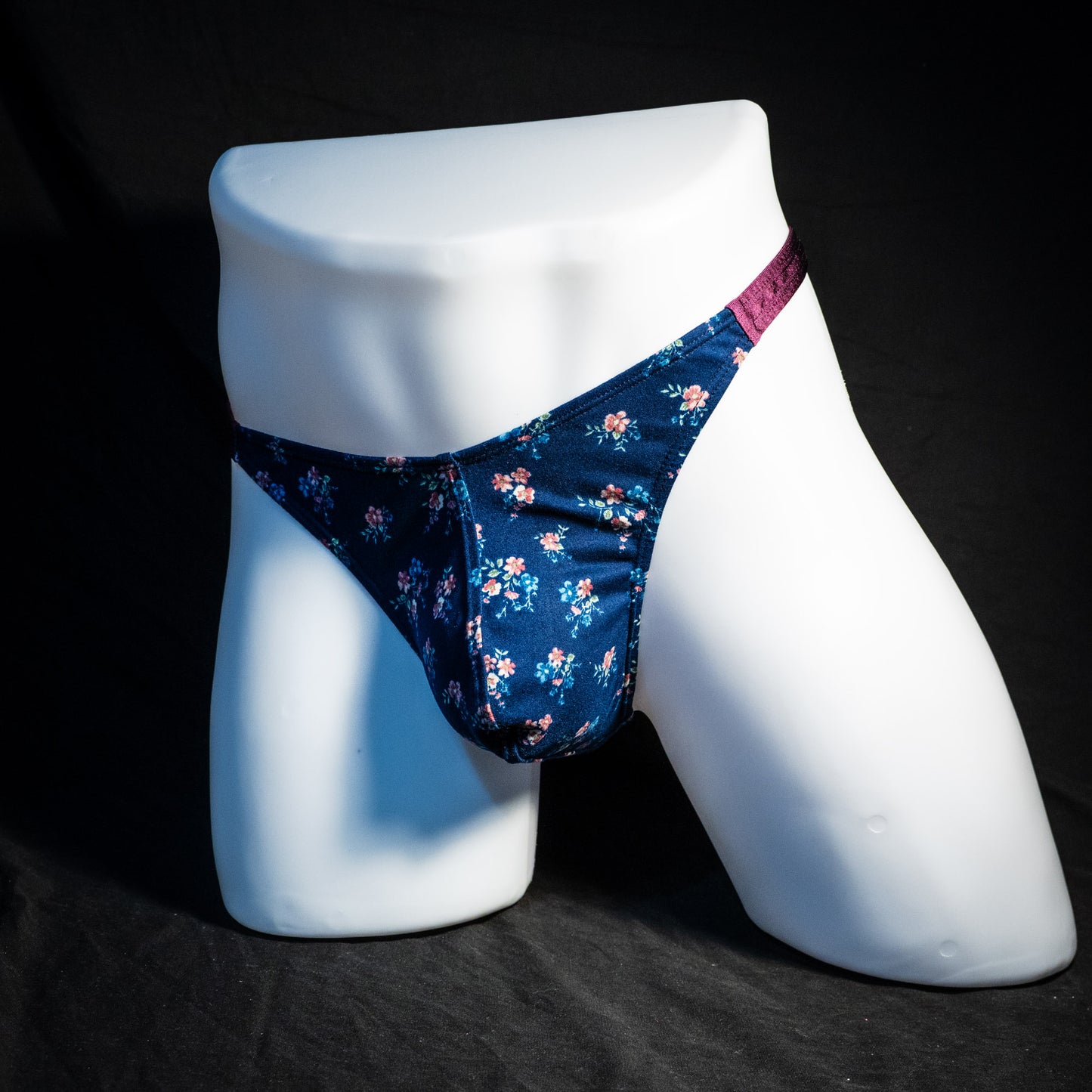 Men's blue floral thong underwear, classic cut, full front angled view.