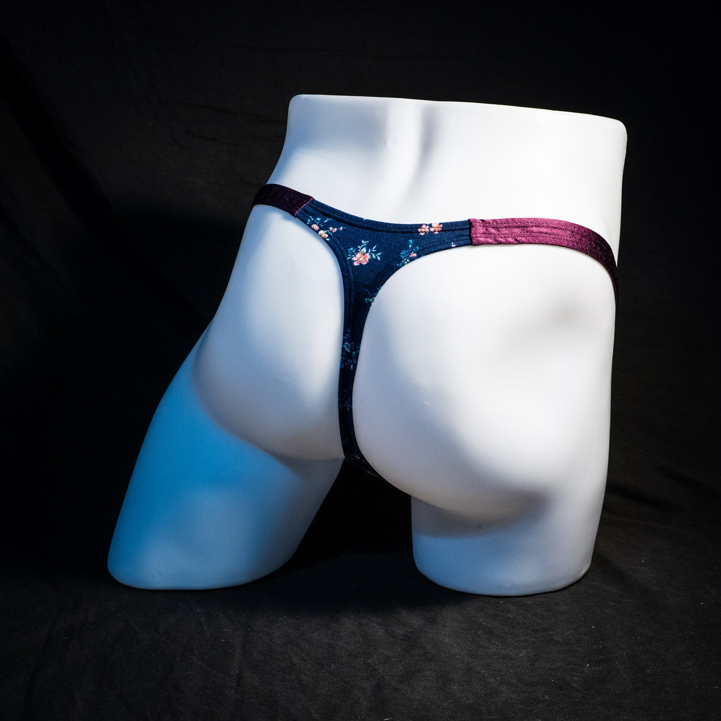 Men's blue floral thong underwear, classic cut, full rear angled view.