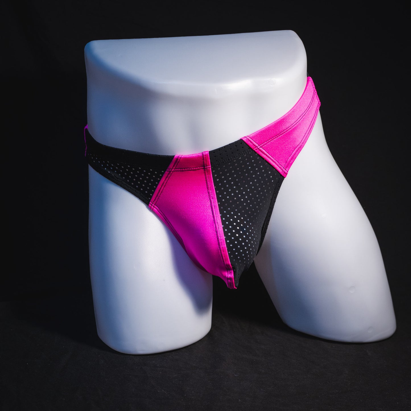 Men's bright pink and black mesh thong underwear, full front view.