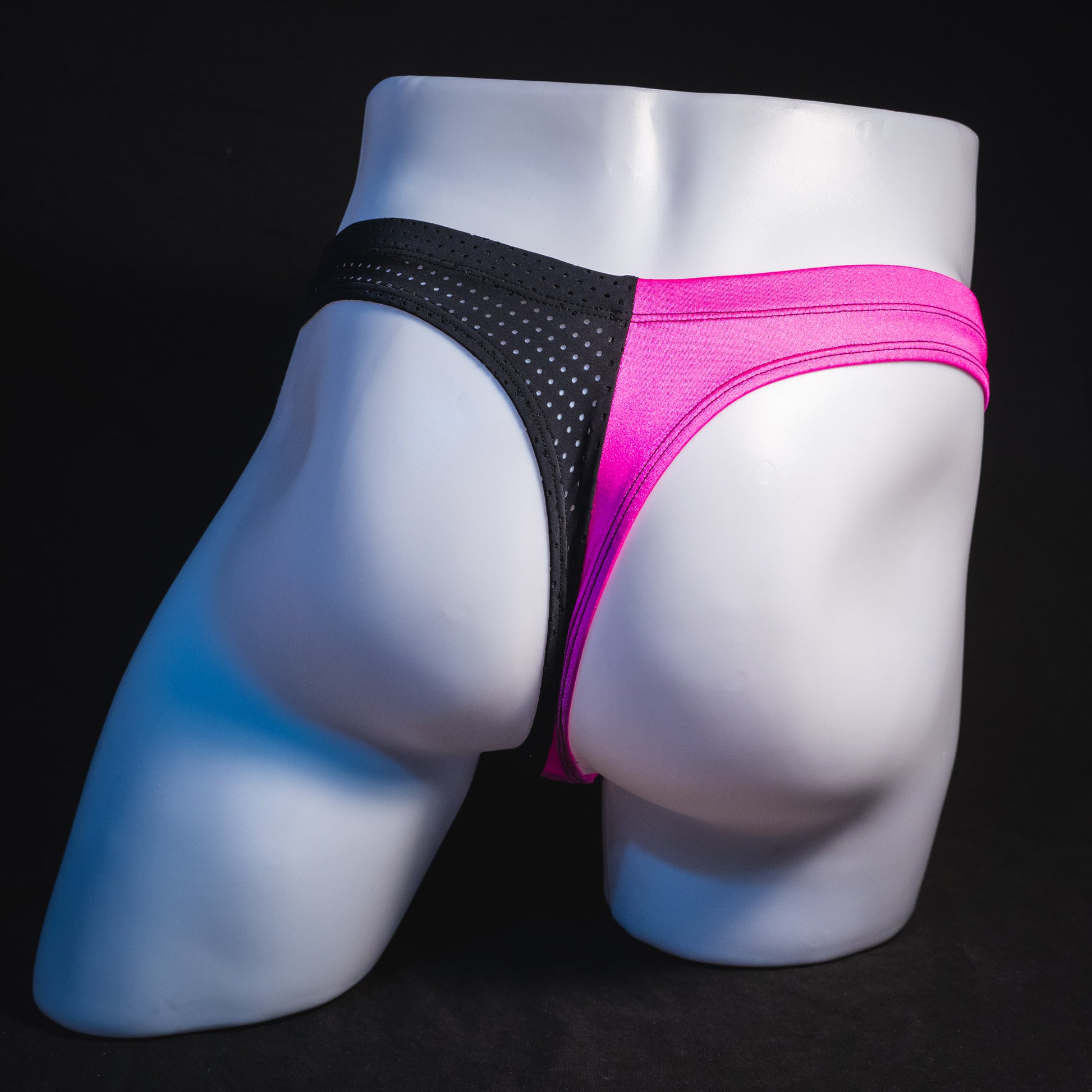 Men's bright pink and black mesh thong underwear, full rear view.