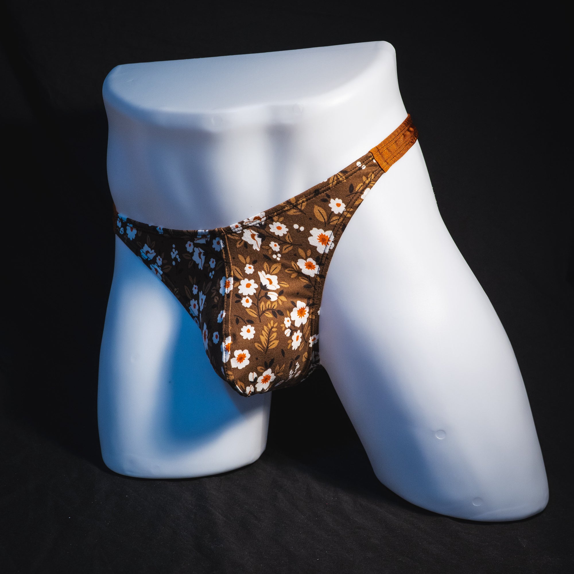Men's brown earth tone floral thong underwear, classic cut, full angled front view.