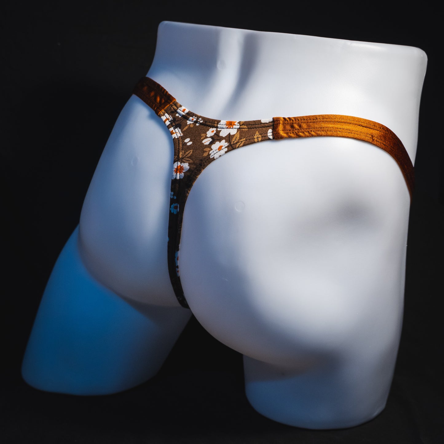 Men's brown earth tone floral thong underwear, classic cut, full angled rear view.
