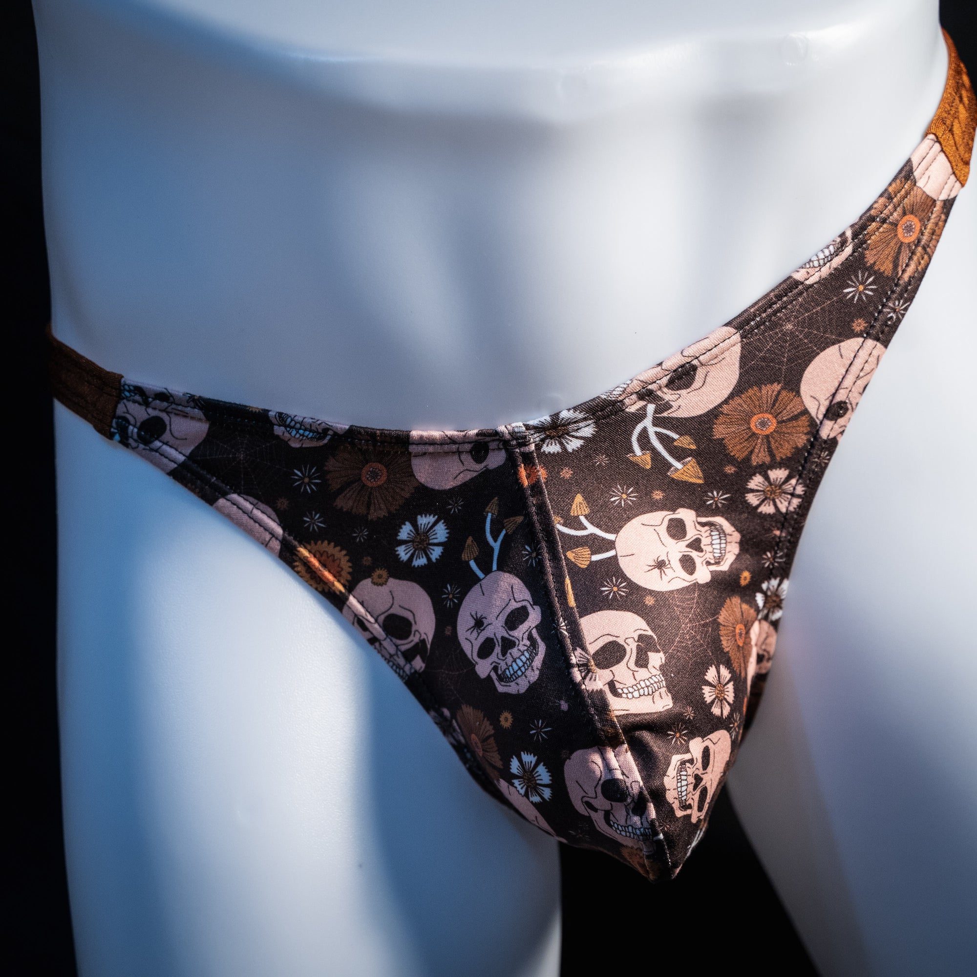 Men's brown skull patterned thong underwear, classic cut, front view.