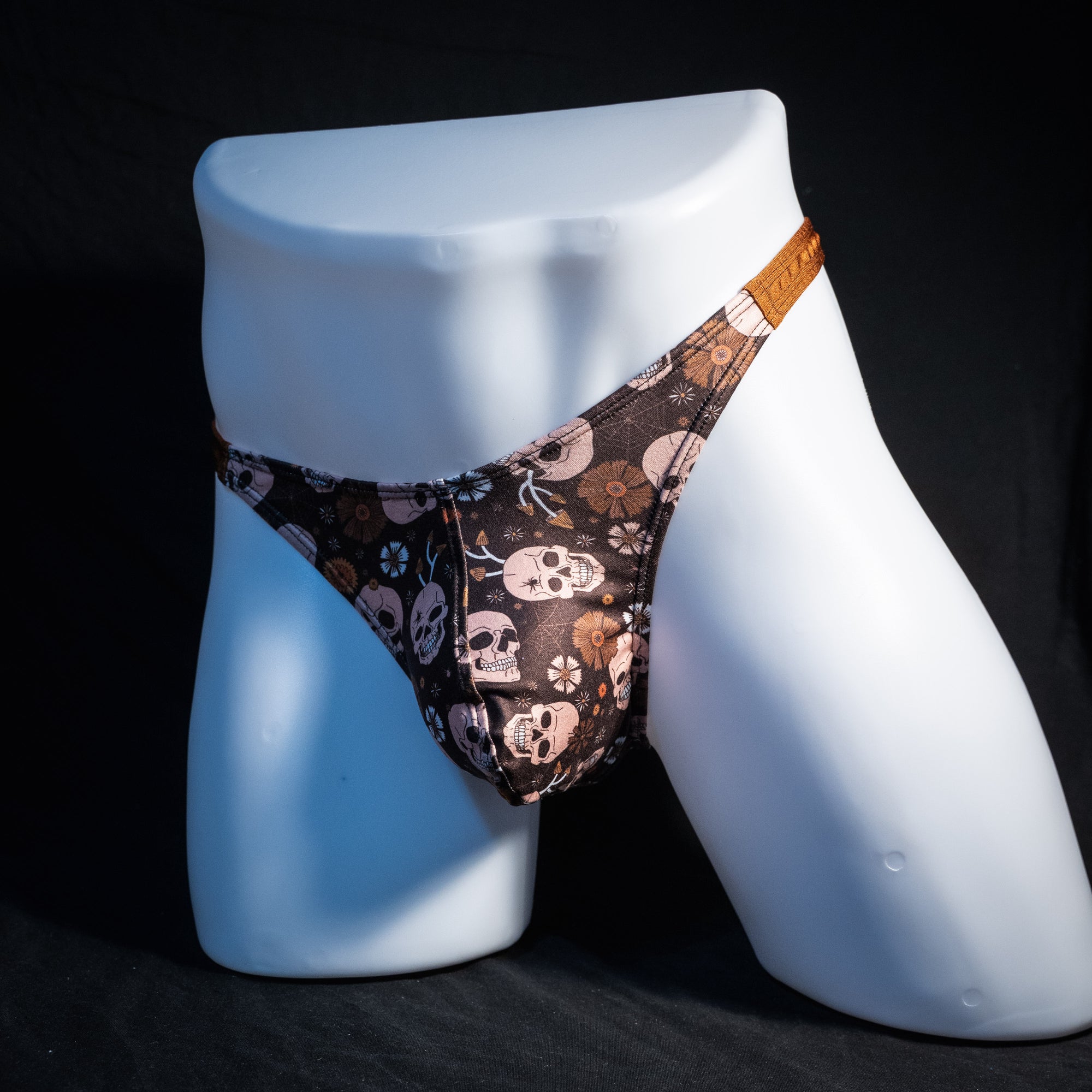 Men's brown skull patterned thong underwear, classic cut, front view.
