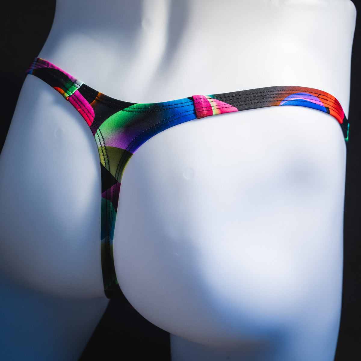 Men's colorful thong underwear, tower cut, angled rear view.