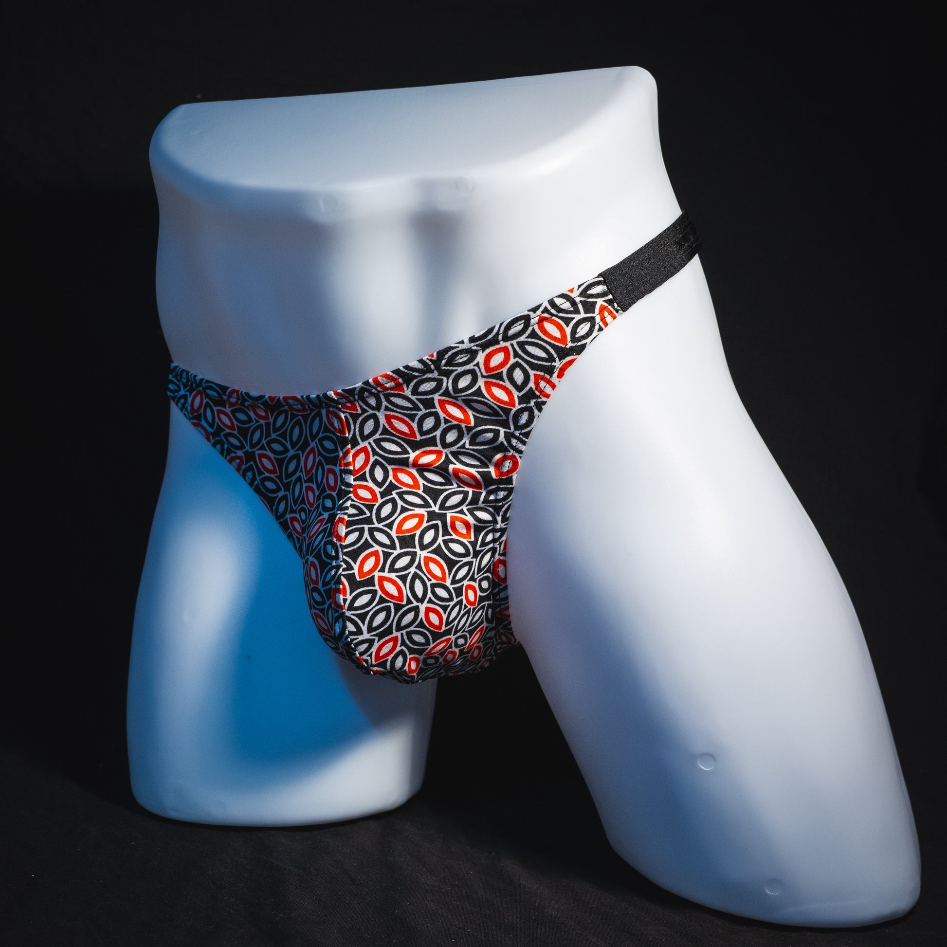 Men's black white and red petal thong underwear, classic cut, full angled front view.