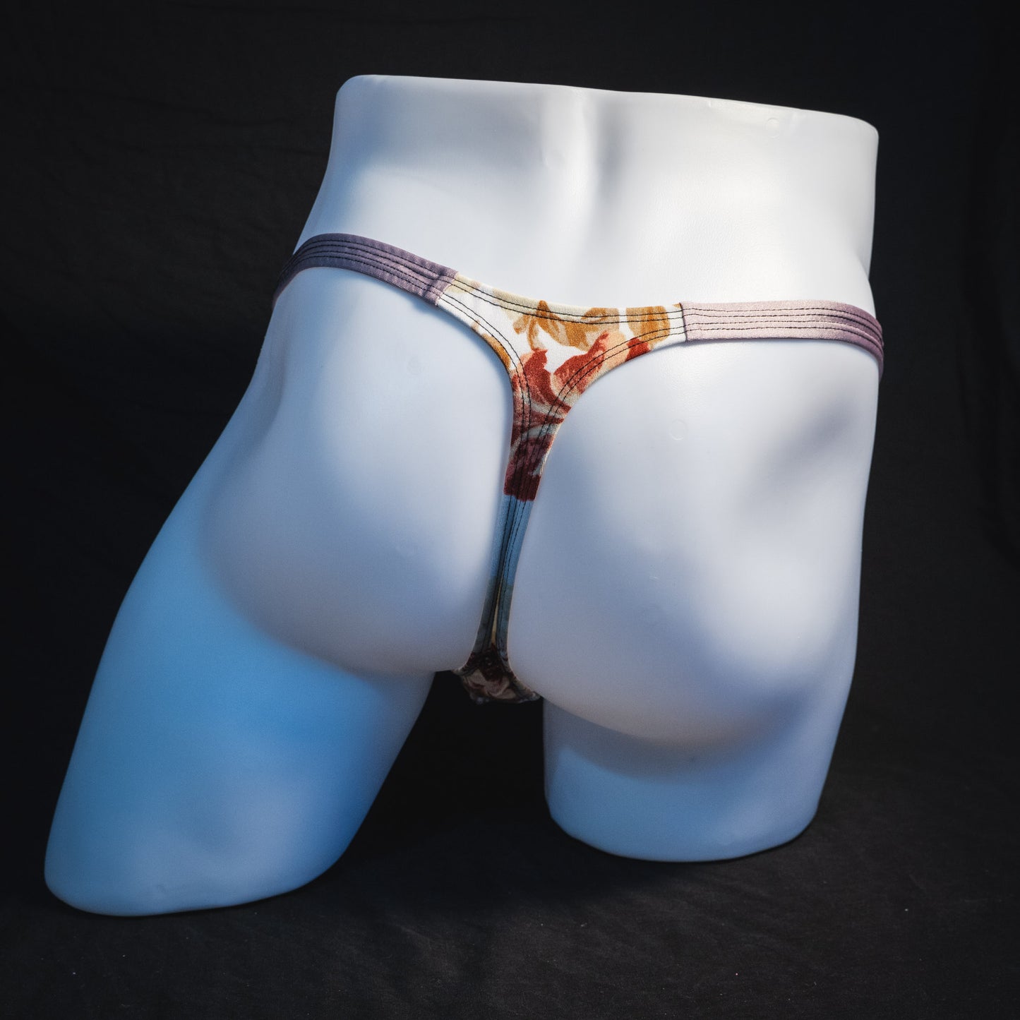 Men's ivory floral thong underwear, classic cut, full rear view.