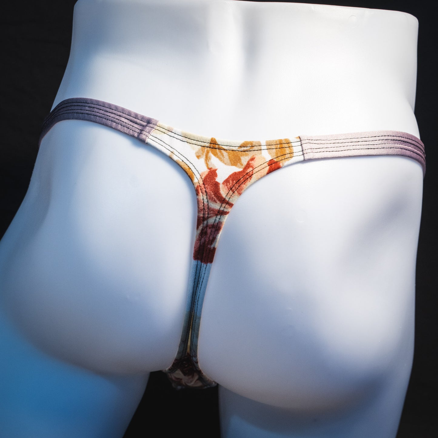 Men's ivory floral thong underwear, classic cut, rear view.