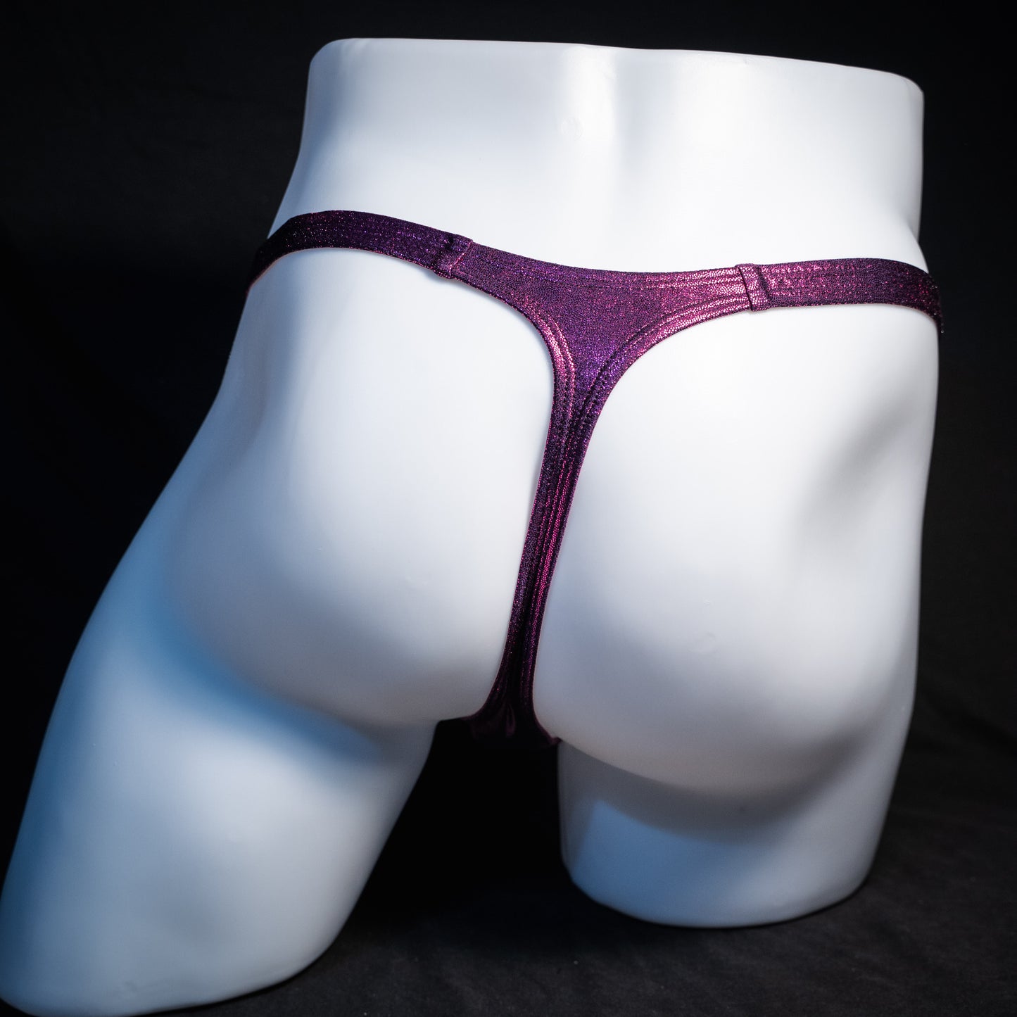 Men's fuchsia metallic thong underwear, classic cut, rear view.
