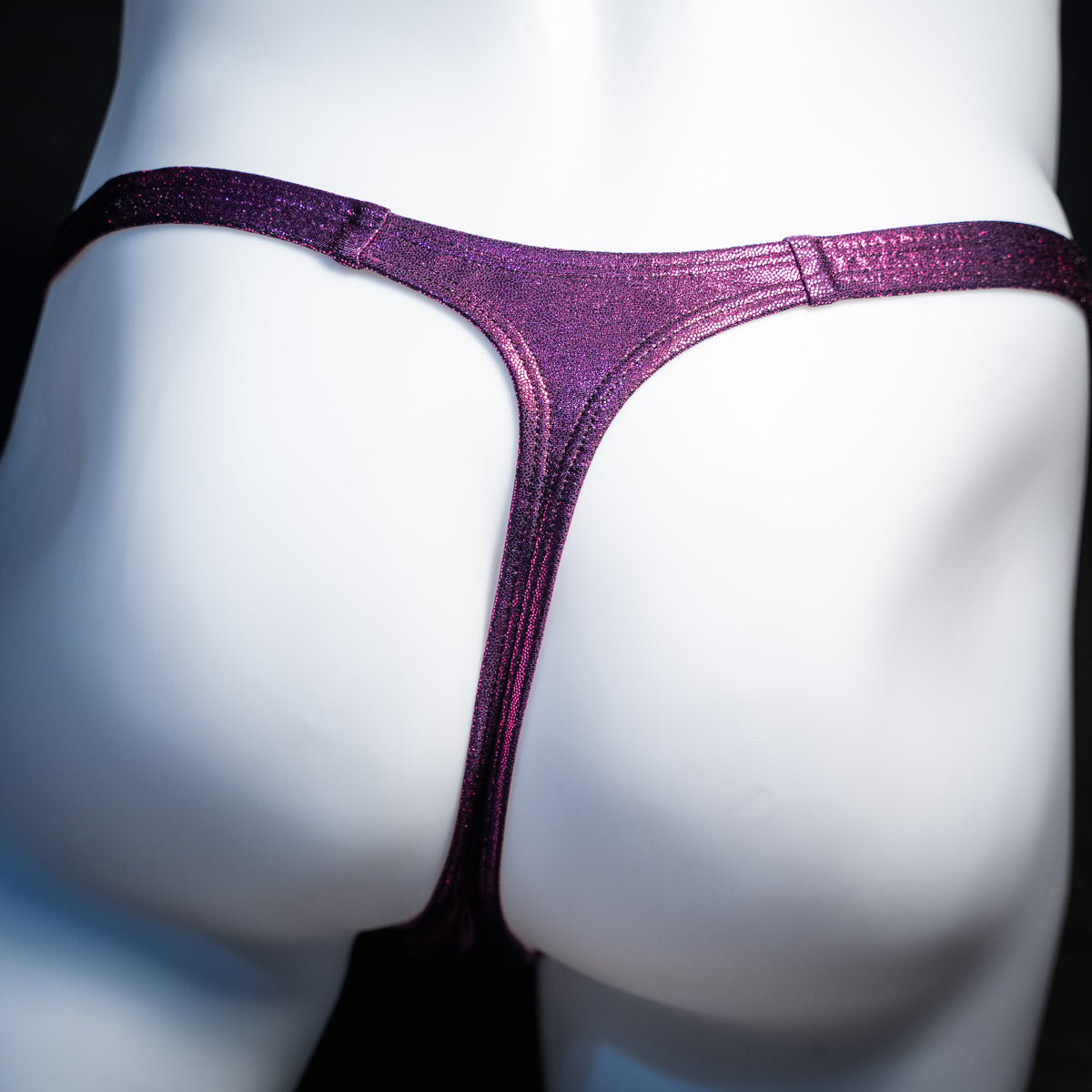 Men's fuchsia metallic thong underwear, classic cut, rear view.