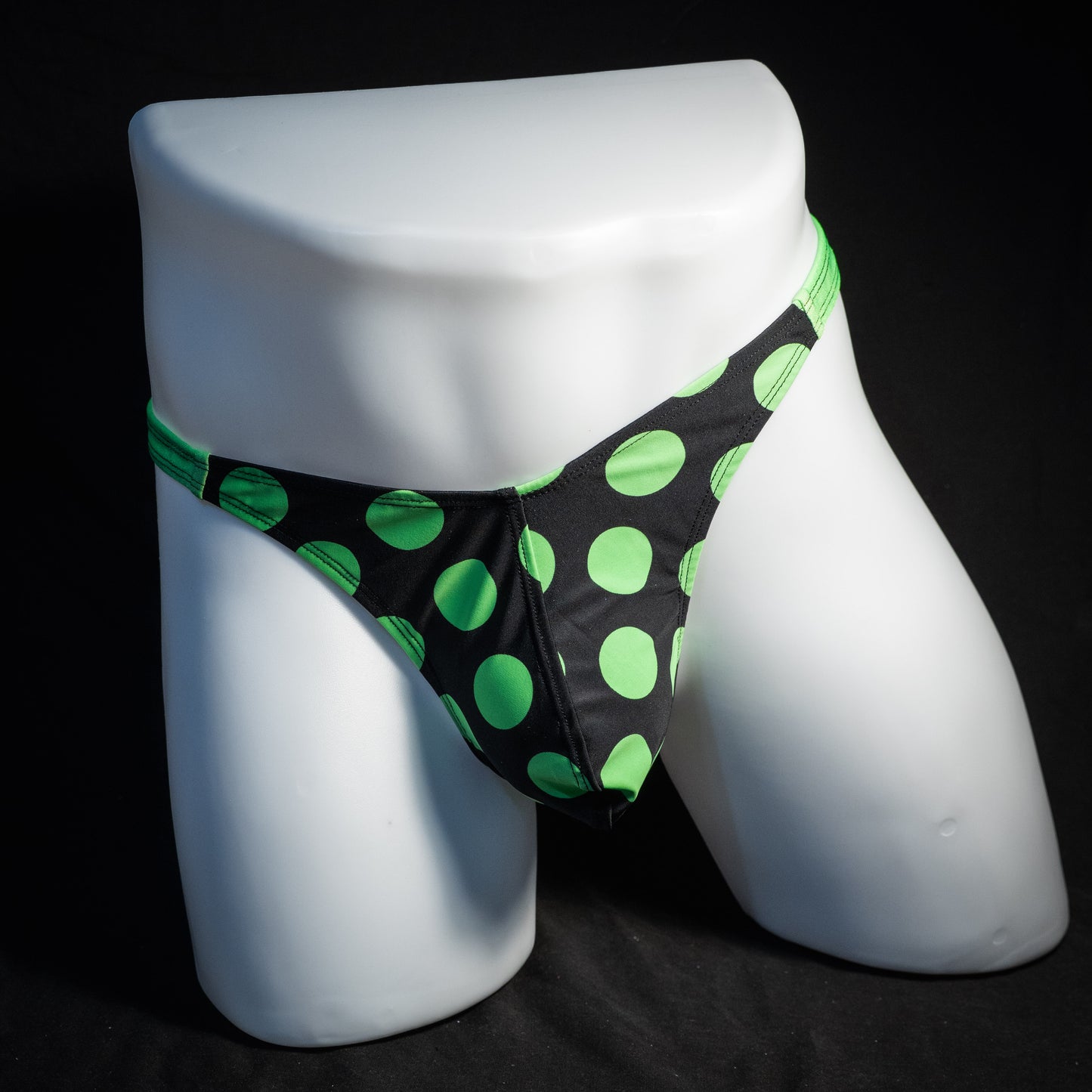 Men's green and black polka dot thong underwear, classic cut, front view.