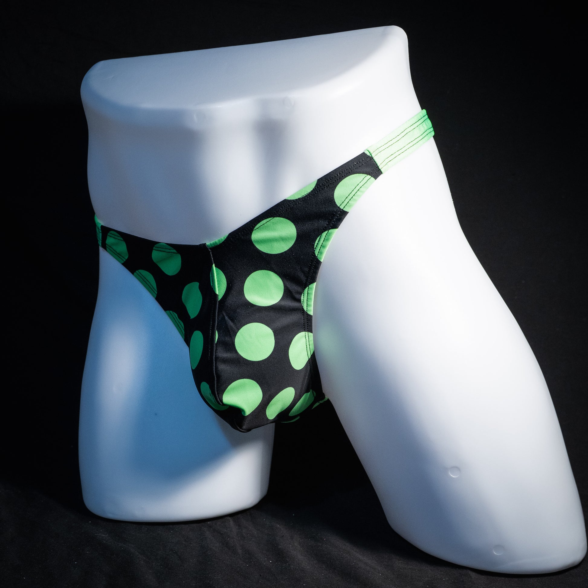 Men's green and black polka dot thong underwear, classic cut, front view.