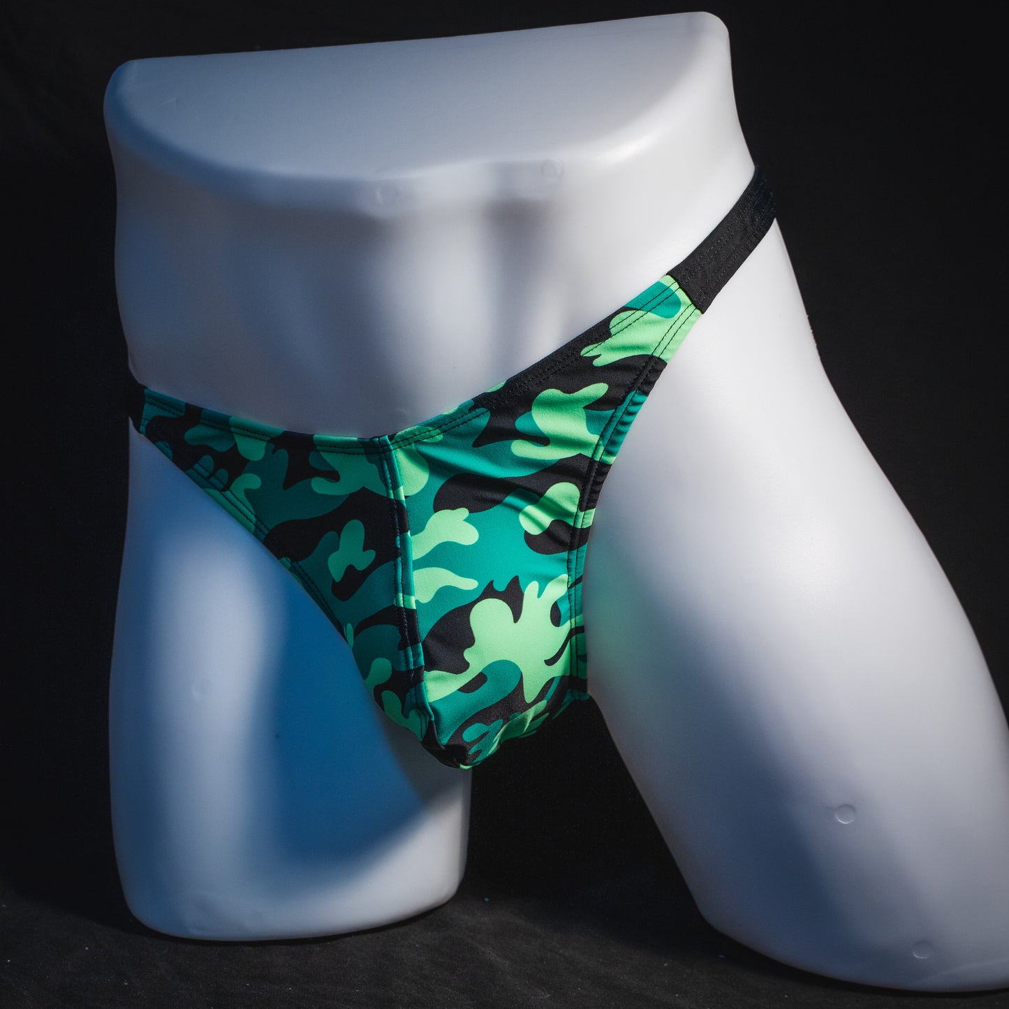 Men's green camo with black straps thong underwear, classic cut, angled full front view.