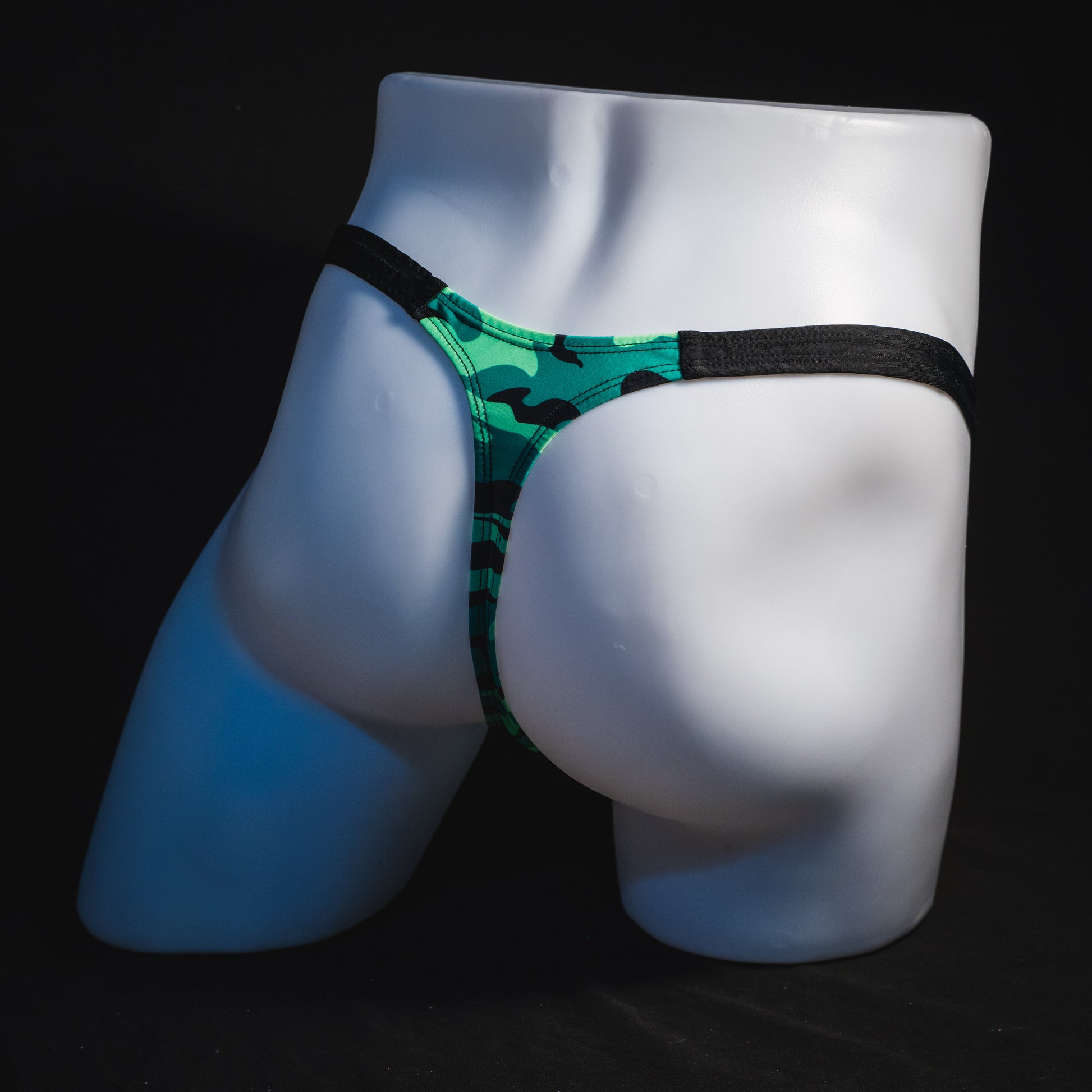 Men's green camo with black straps thong underwear, classic cut, angled full rear view.
