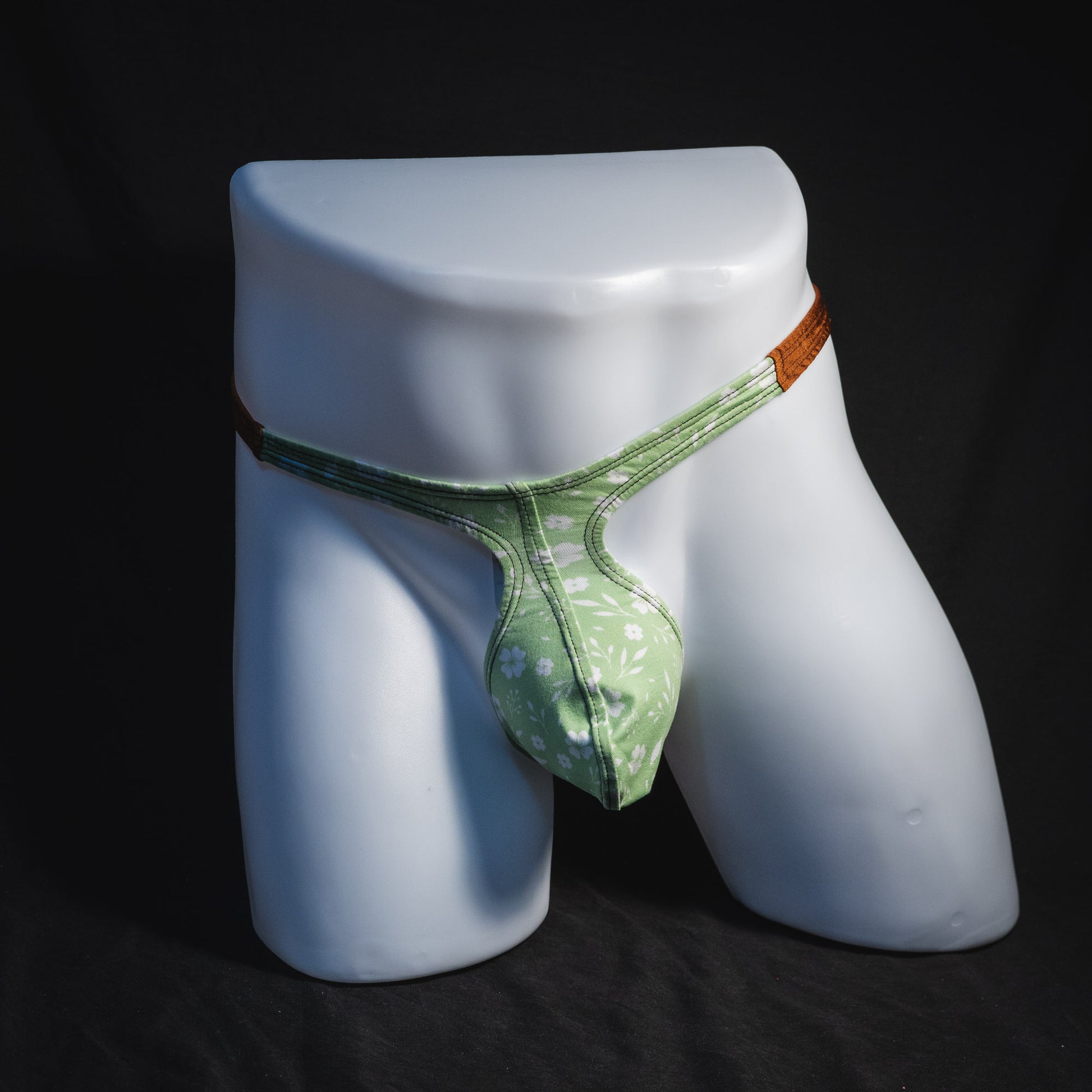 Men's green floral thong underwear, tear drop cut, full front view.