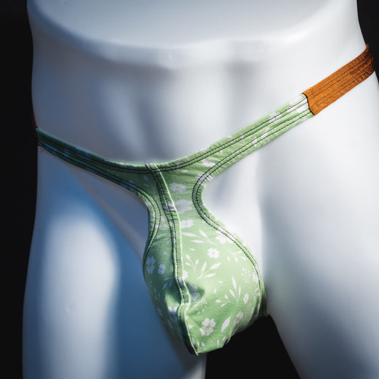 Men's green floral thong underwear, tear drop cut, angled front view.