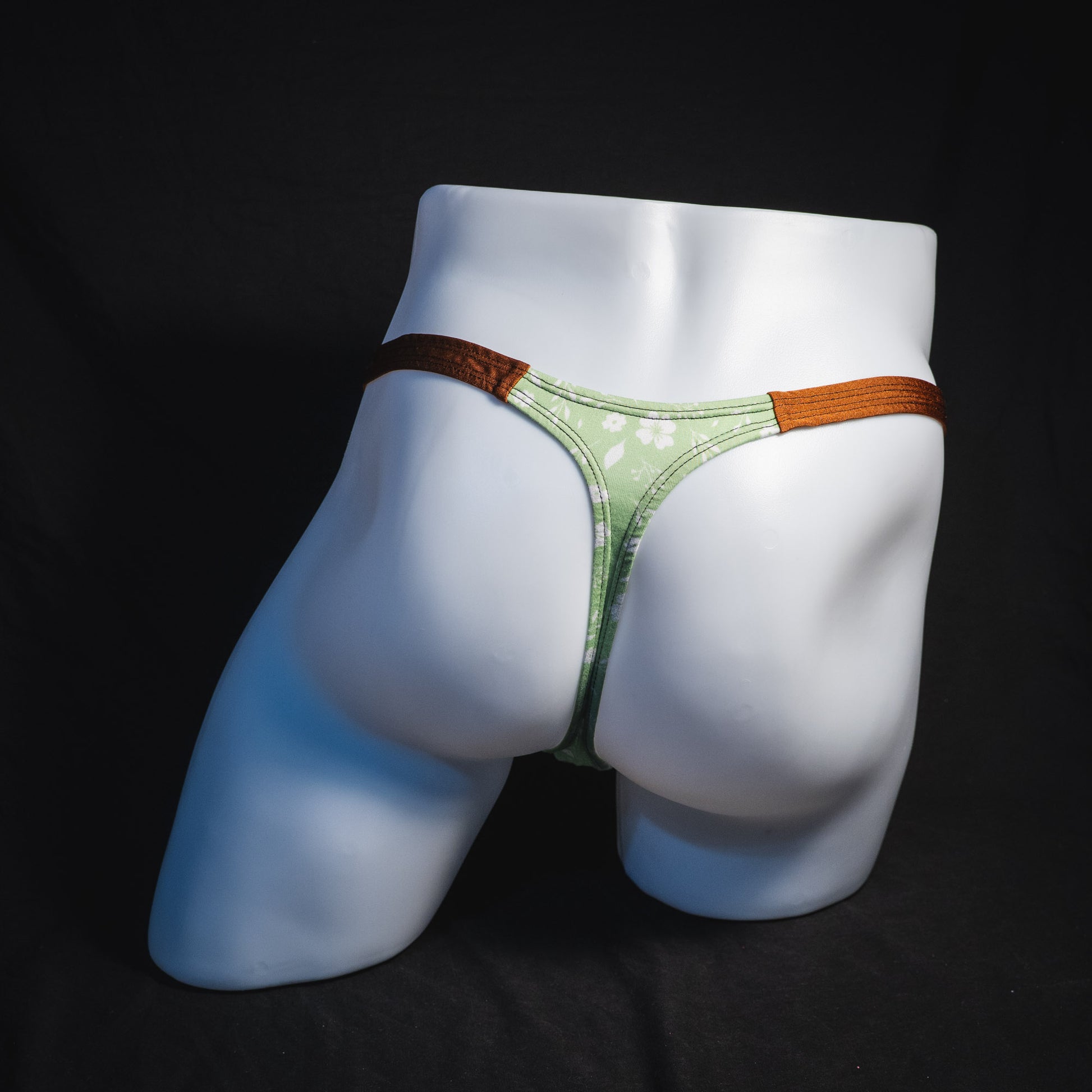 Men's green floral thong underwear, tear drop cut, full rear view.