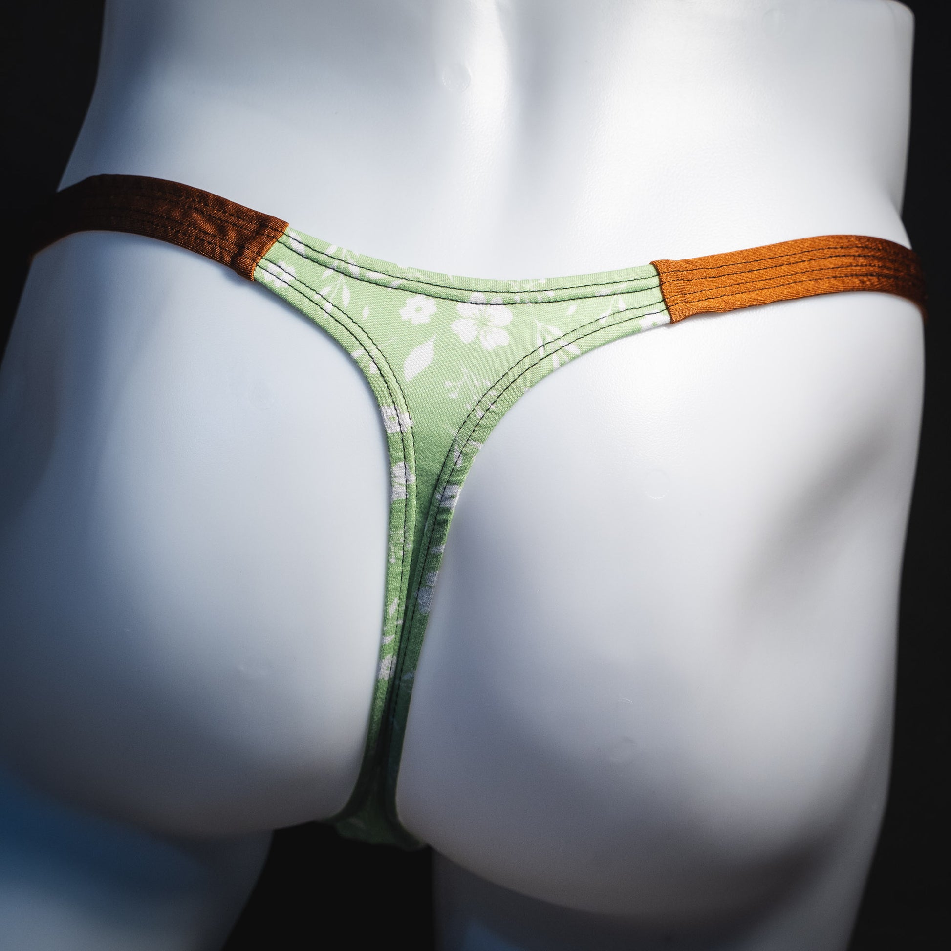 Men's green floral thong underwear, tear drop cut, rear view.