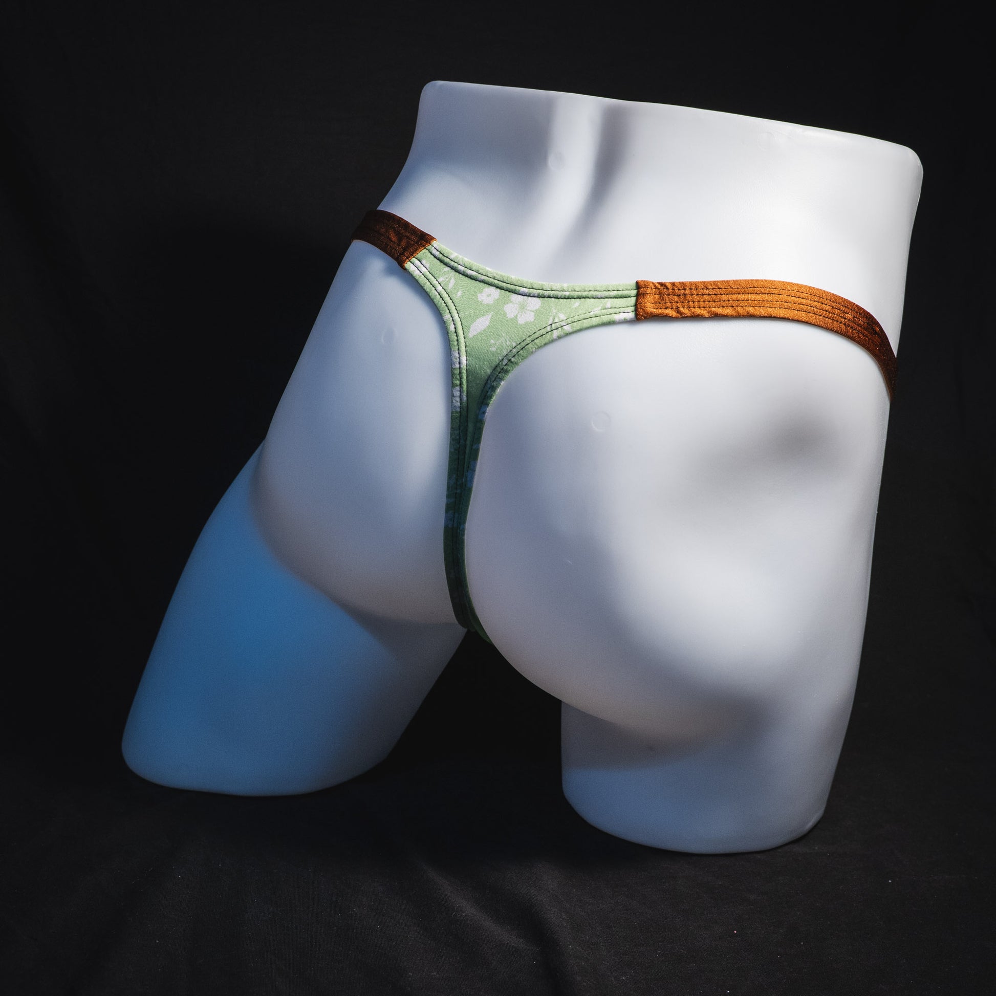 Men's green floral thong underwear, tear drop cut, full angled rear view.