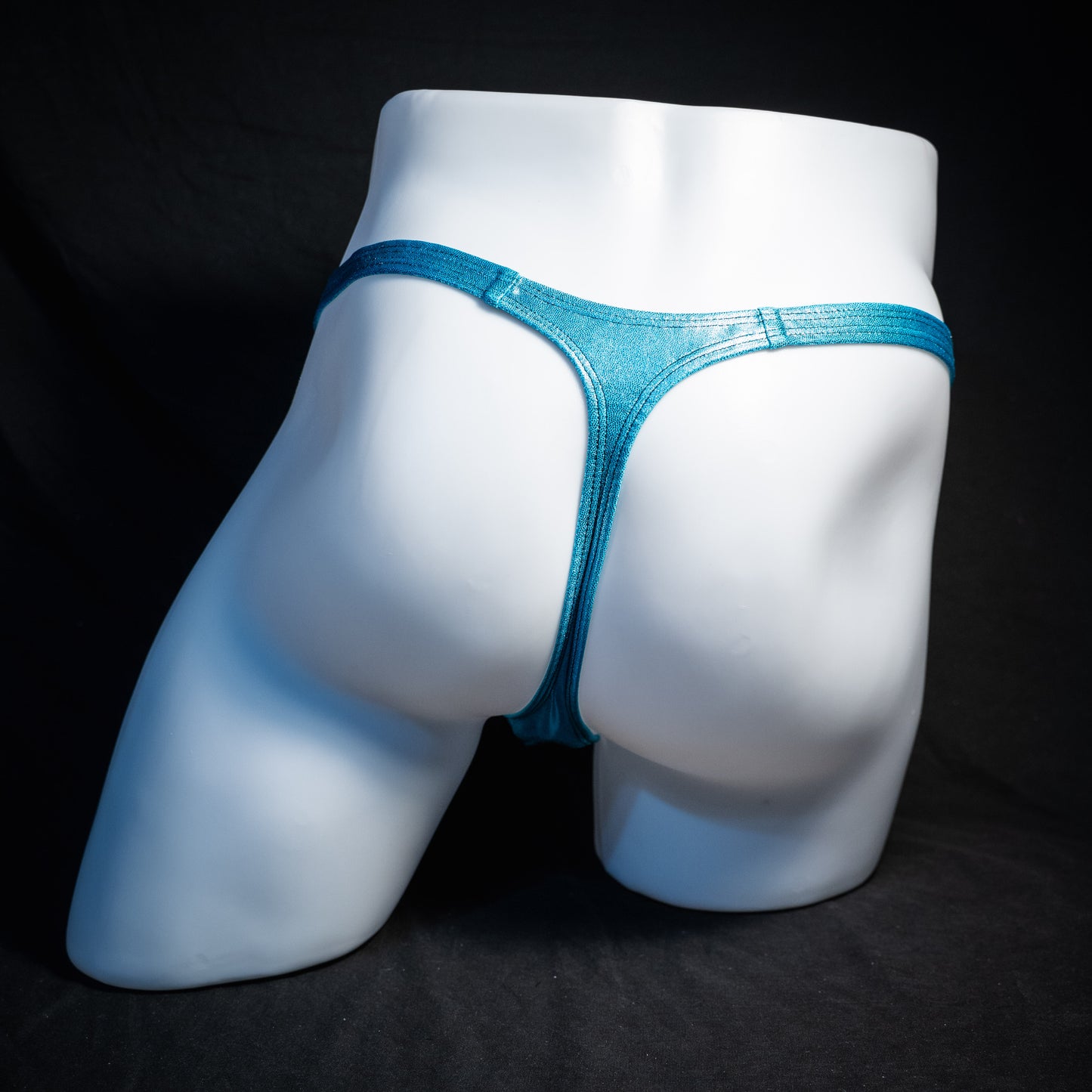 Men's metallic Hawaiian baby blue thong underwear, classic cut, rear view.