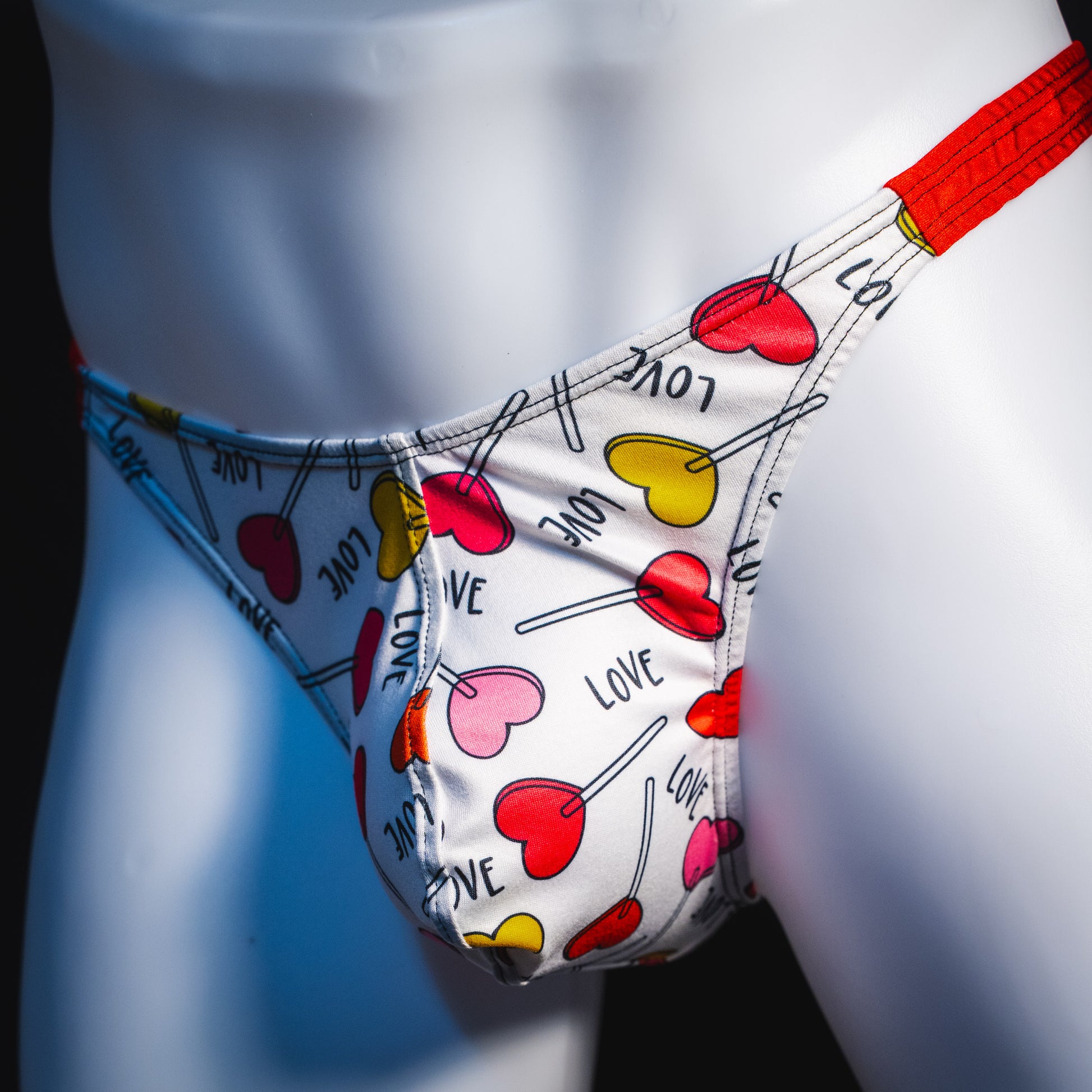 Men's heart shaped lollipops thong underwear, classic cut, angled front view.