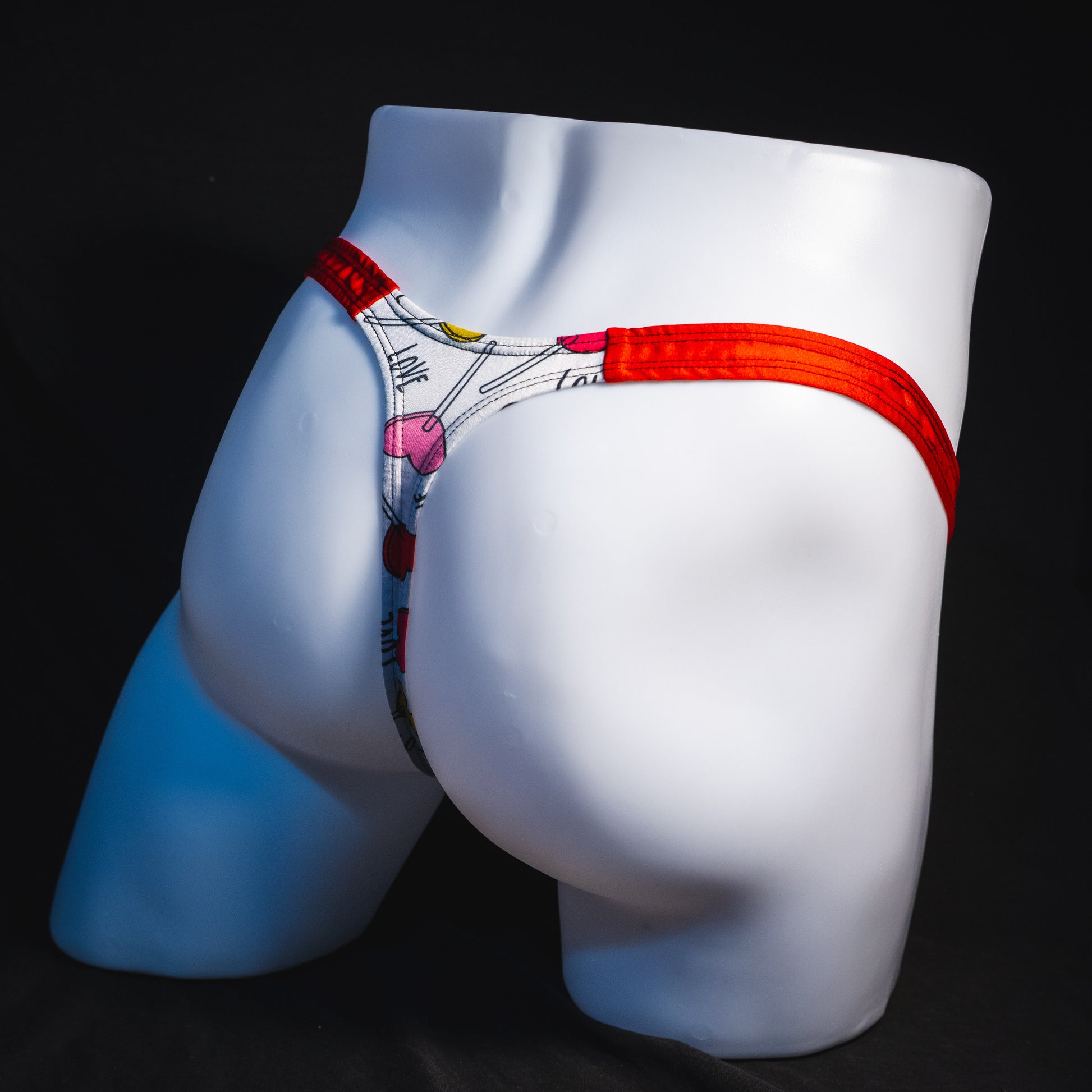 Men's heart shaped lollipops thong underwear, classic cut, full angled rear view.