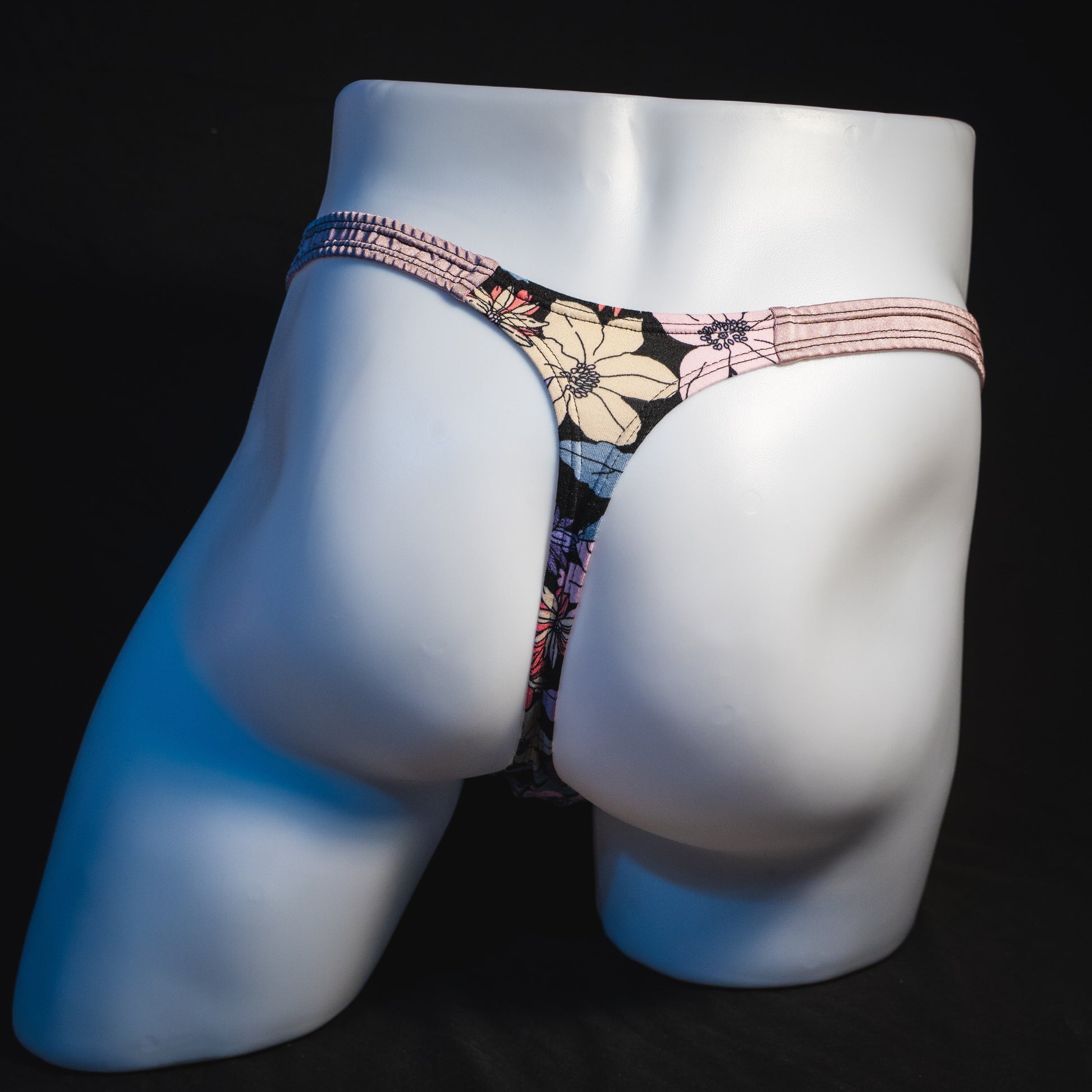 Men's purple floral with lilac straps thong underwear, classic cut, full rear view.