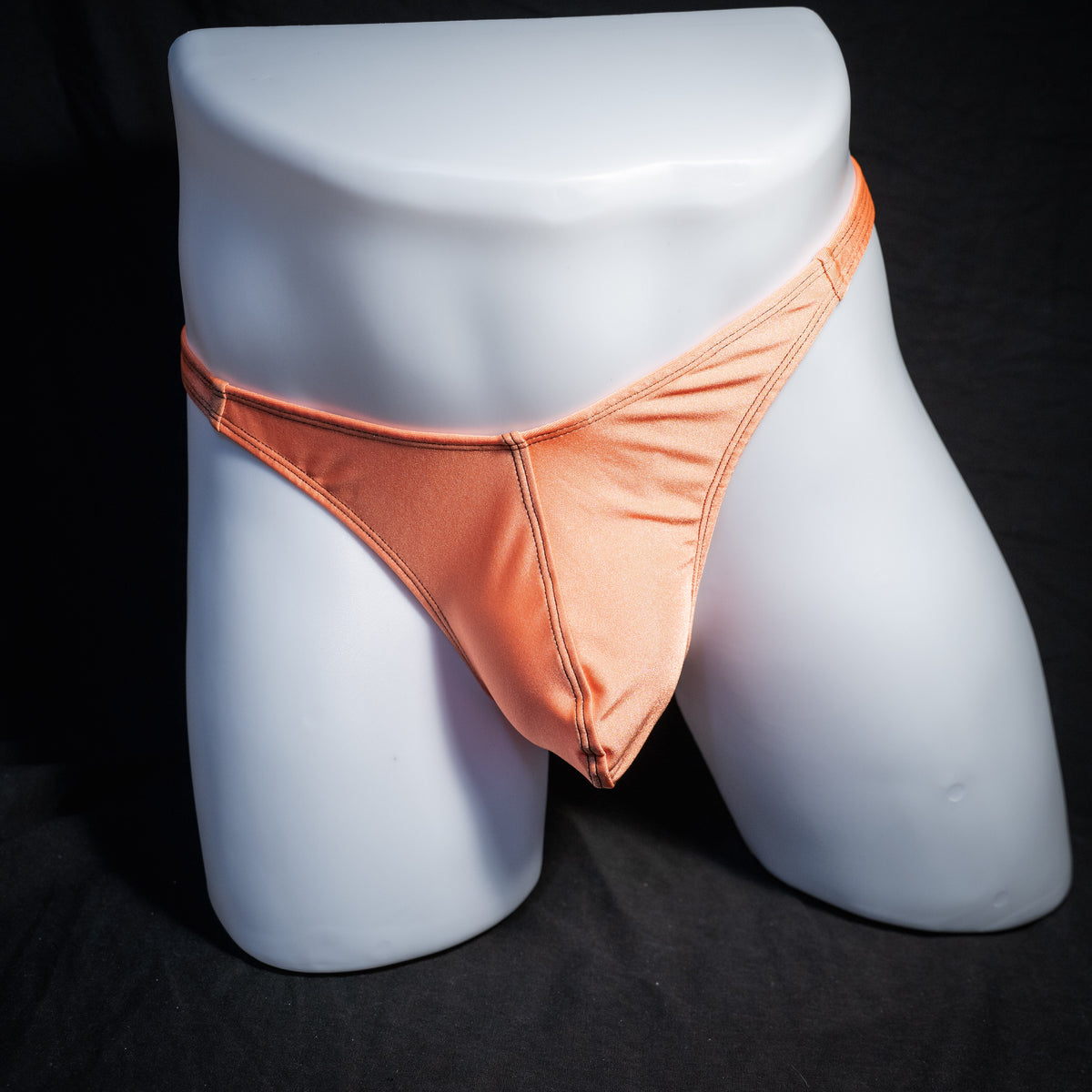 Men's neon orange thong underwear, classic cut, front view.