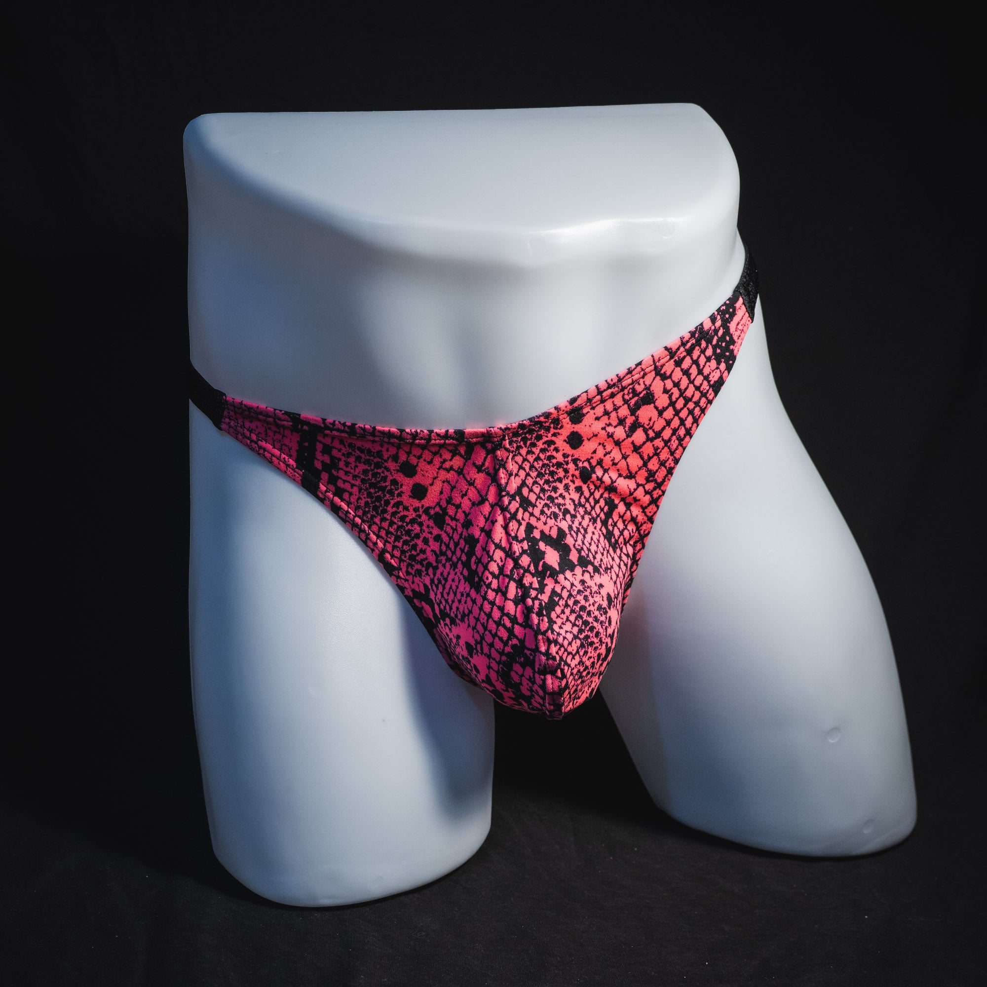 Men's neon pink snakeskin thong underwear, classic cut, full front view.