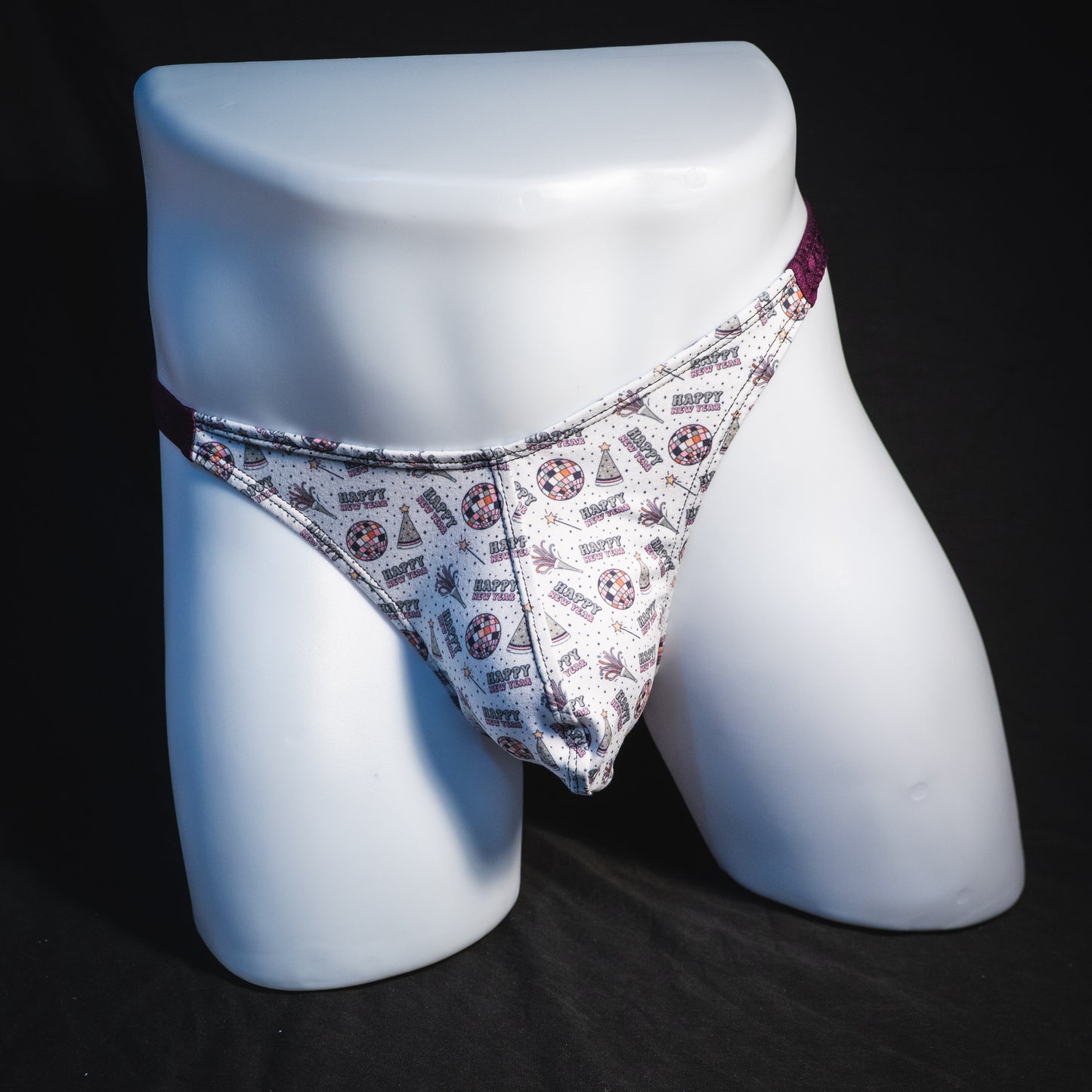 Men's new years thong underwear with shiny purple straps, classic cut, full front view.