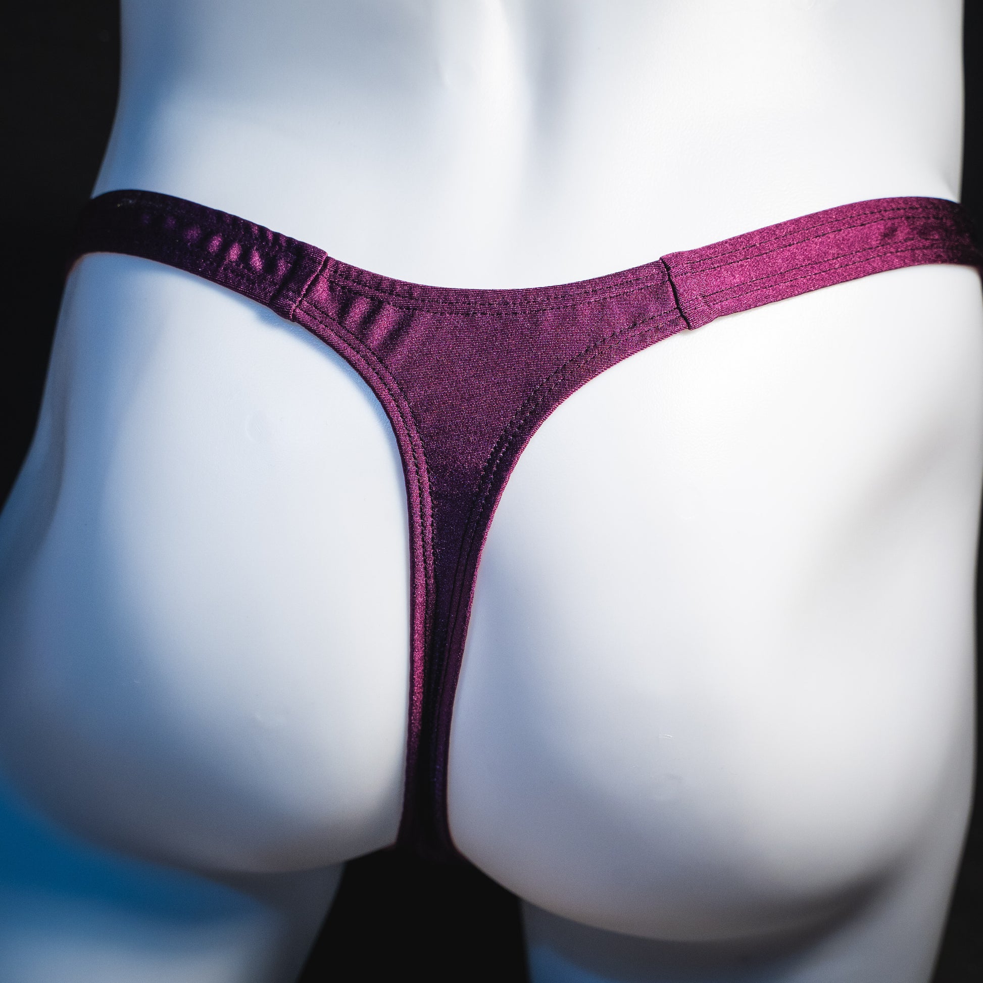 Men's new years thong underwear with shiny purple straps, classic cut, rear view.