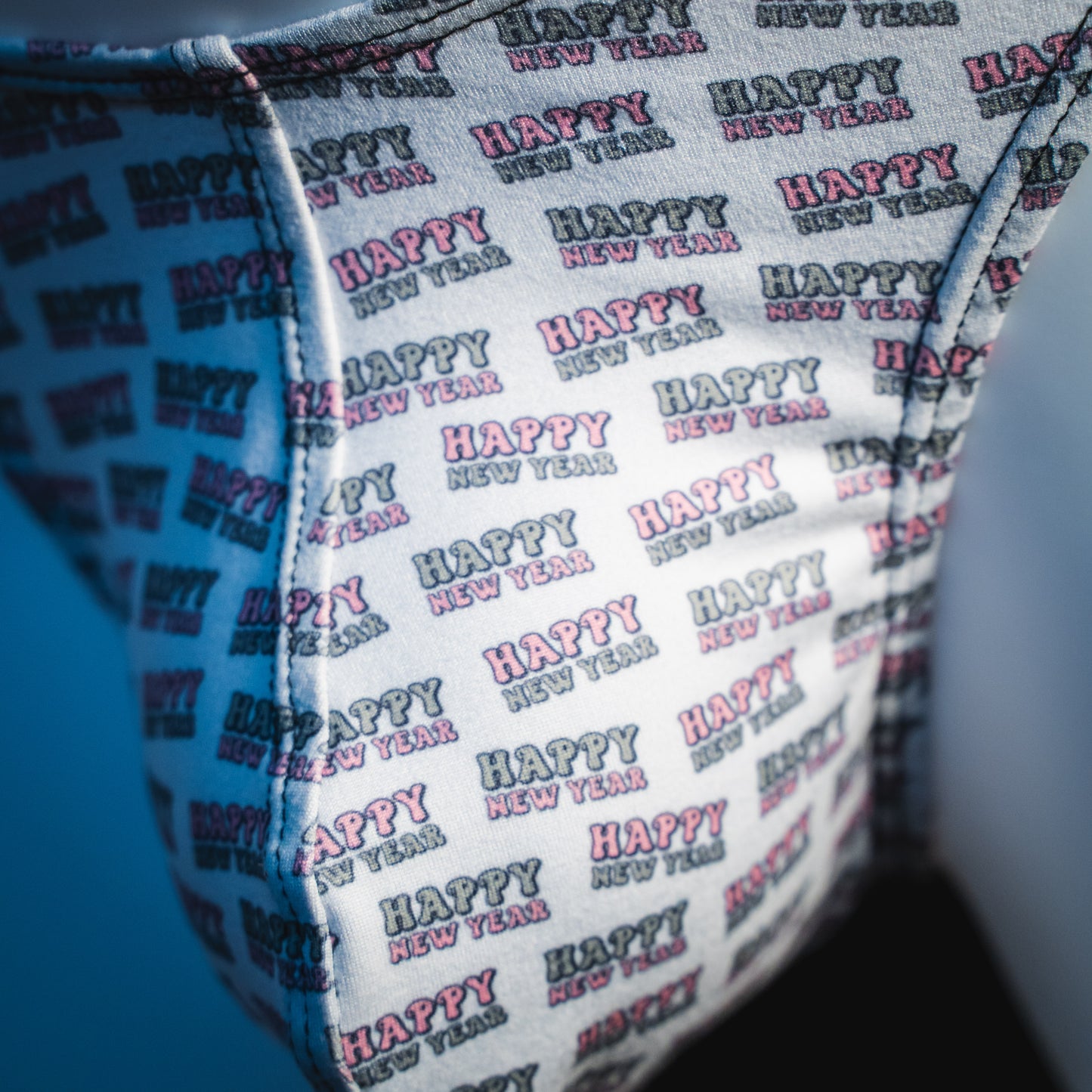 Men's new years thong underwear with black straps, classic cut, close up detailed view.