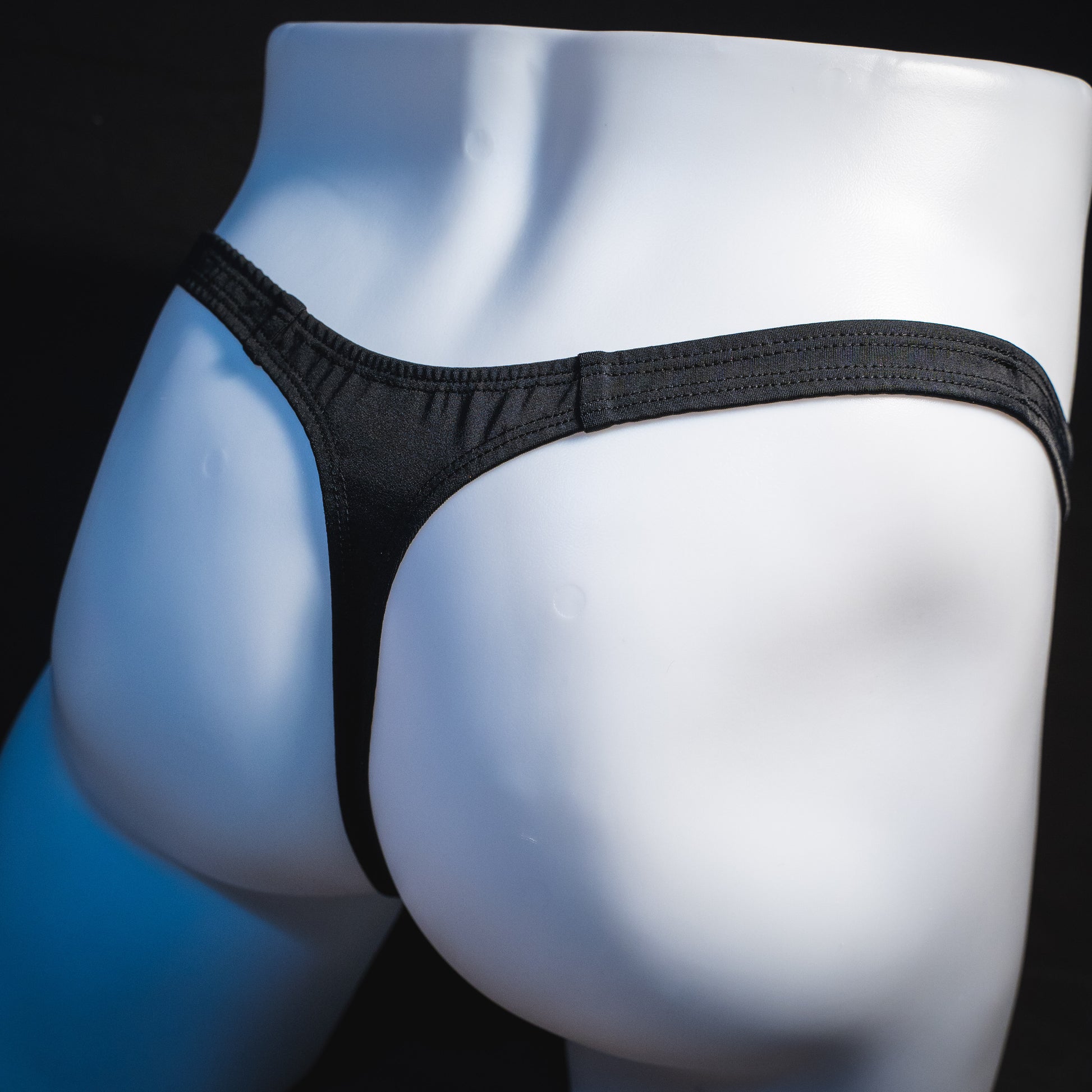 Men's new years thong underwear with black straps, classic cut, angled rear view.