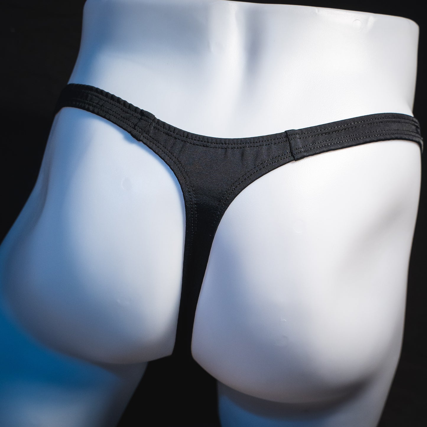 Men's new years thong underwear with black straps, classic cut, rear view.