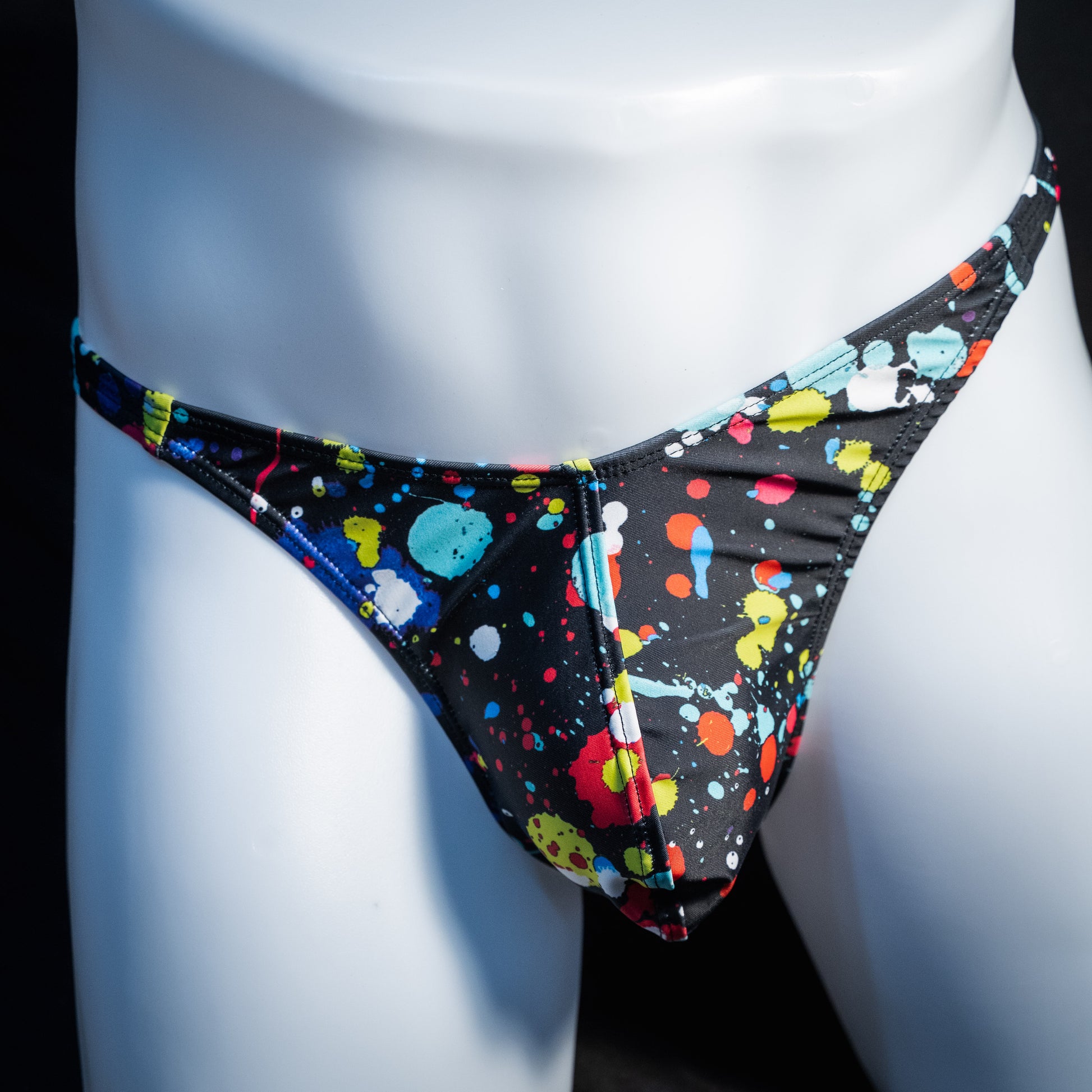 Men's paint splatter thong underwear, classic cut, front view.