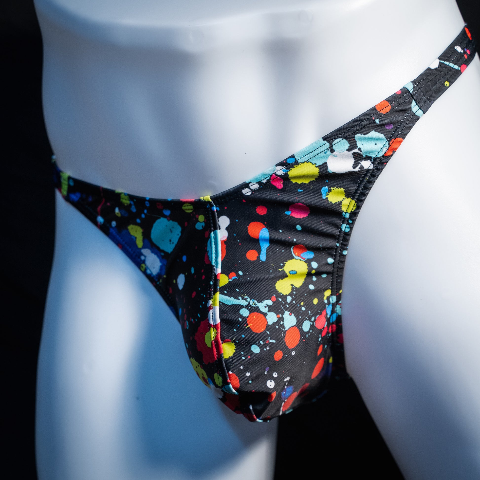 Men's paint splatter thong underwear, classic cut, front view.
