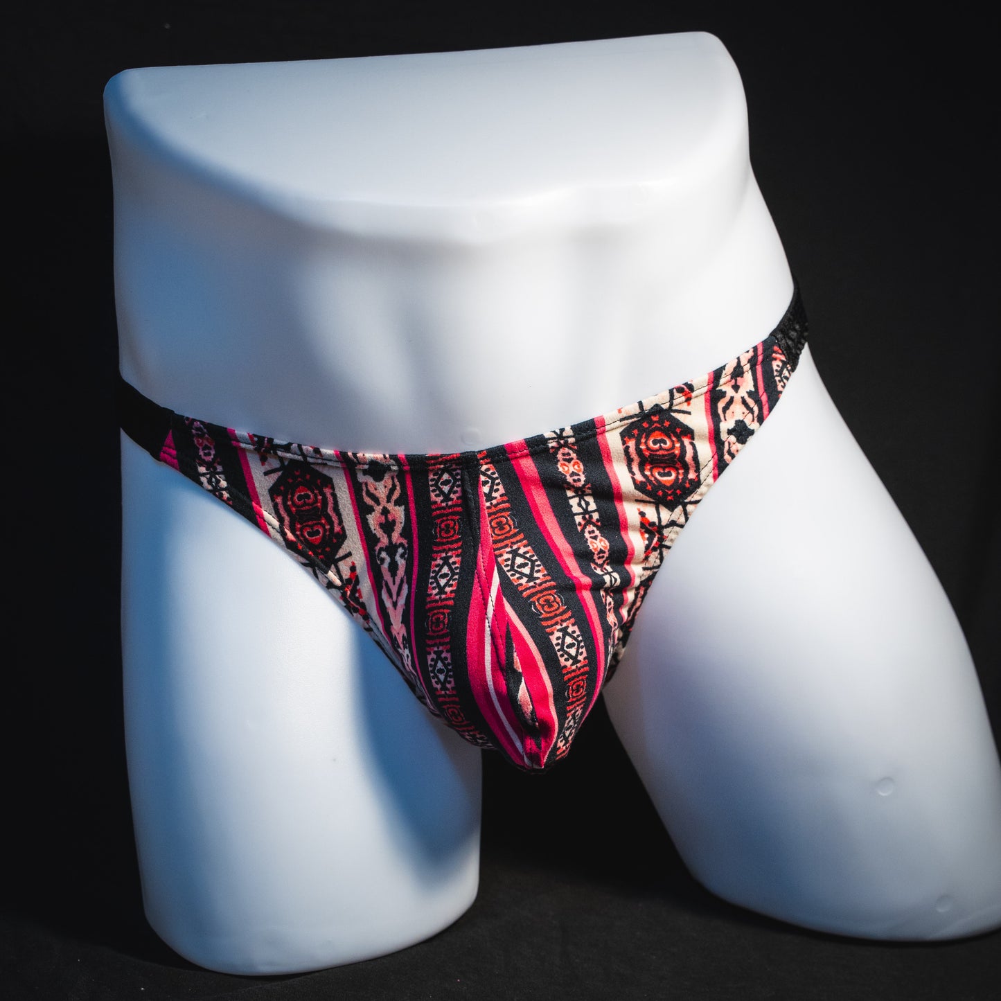 Men's pink bohemian striped thong underwear, classic cut, full front view.